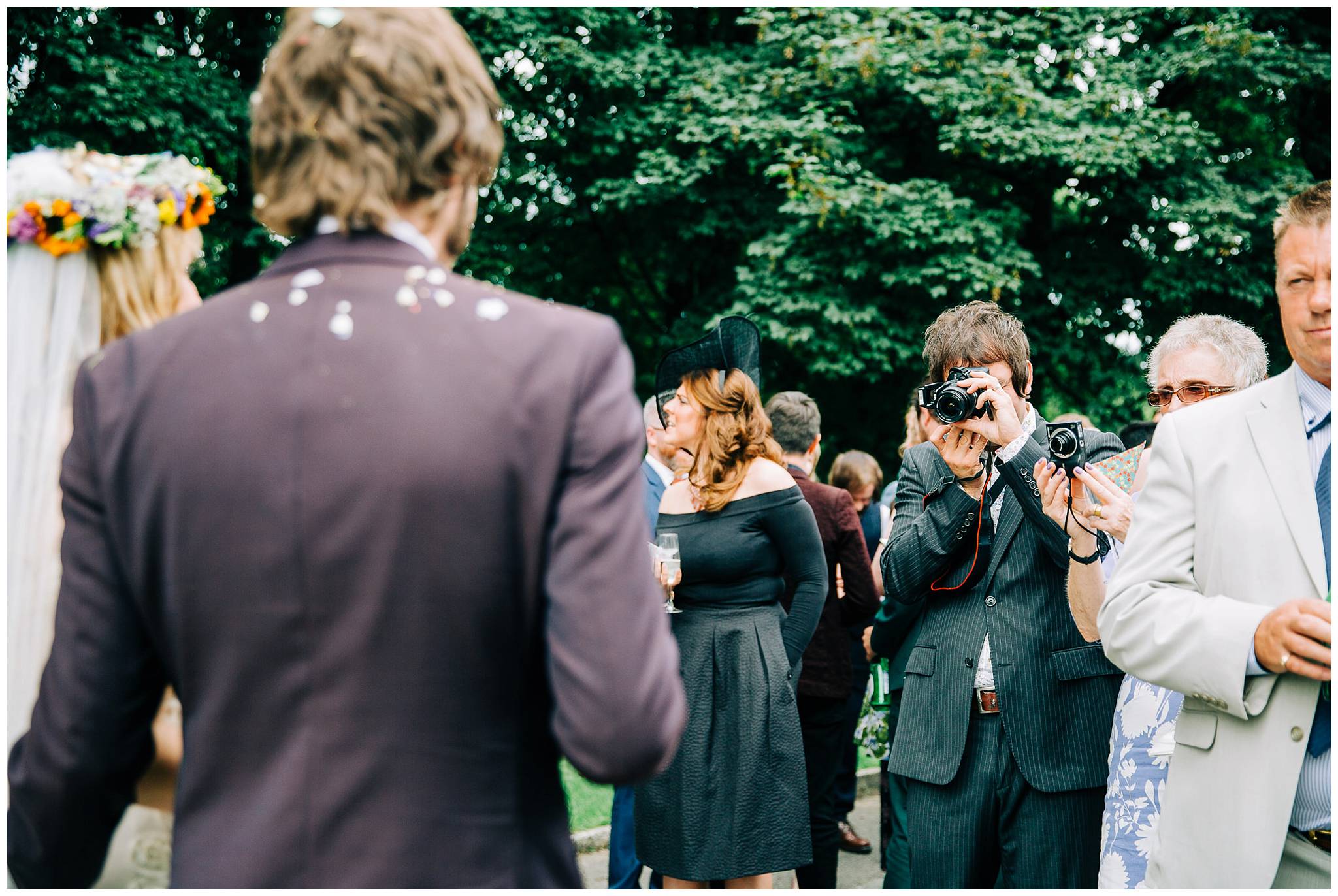 guest with camera talking photo of bride and groom
