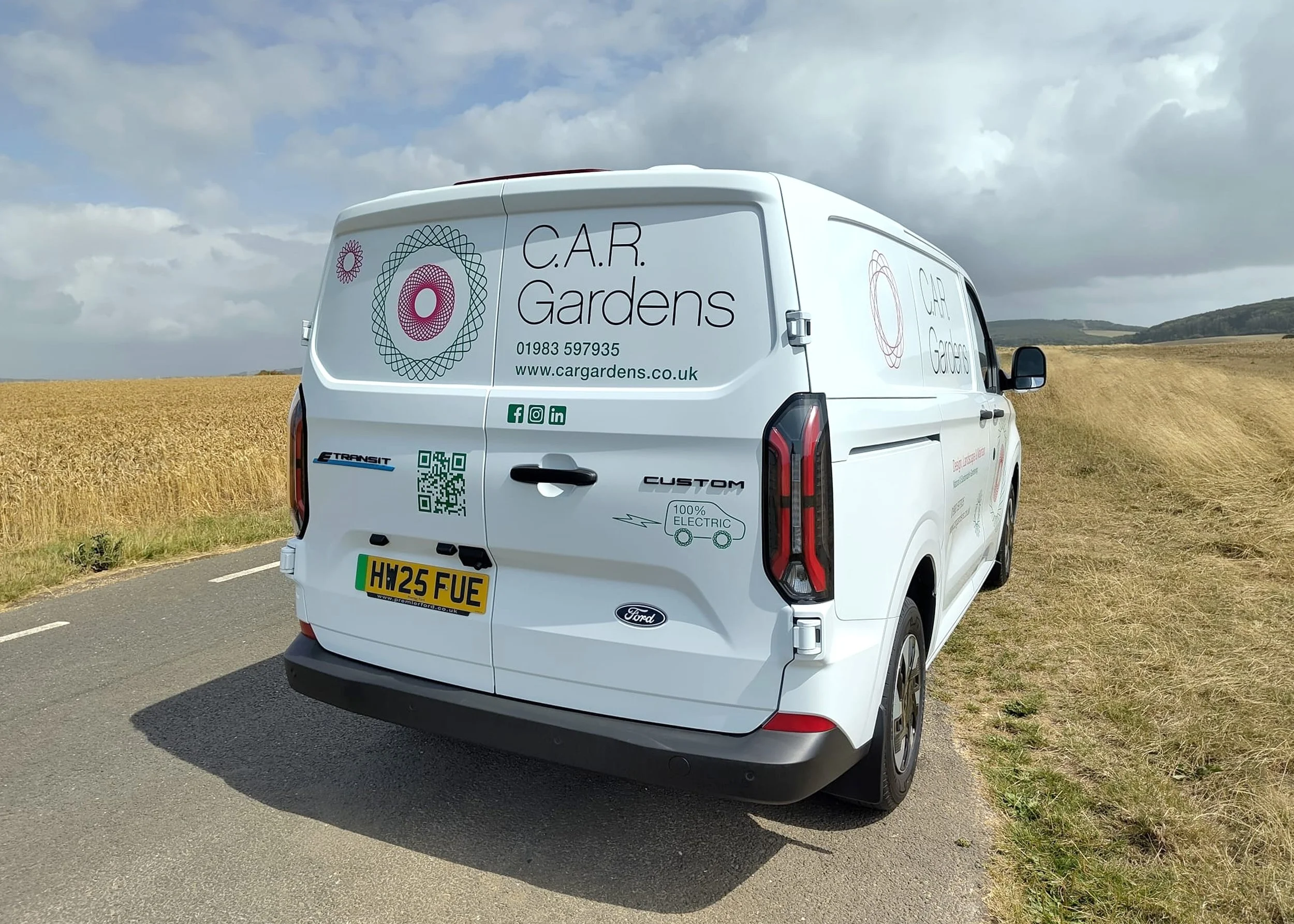 Back of one of C.A.R. Garden’s 9 white vans displaying the brandmark and freeform spirograph artwork. This is also a 100% Electric van.