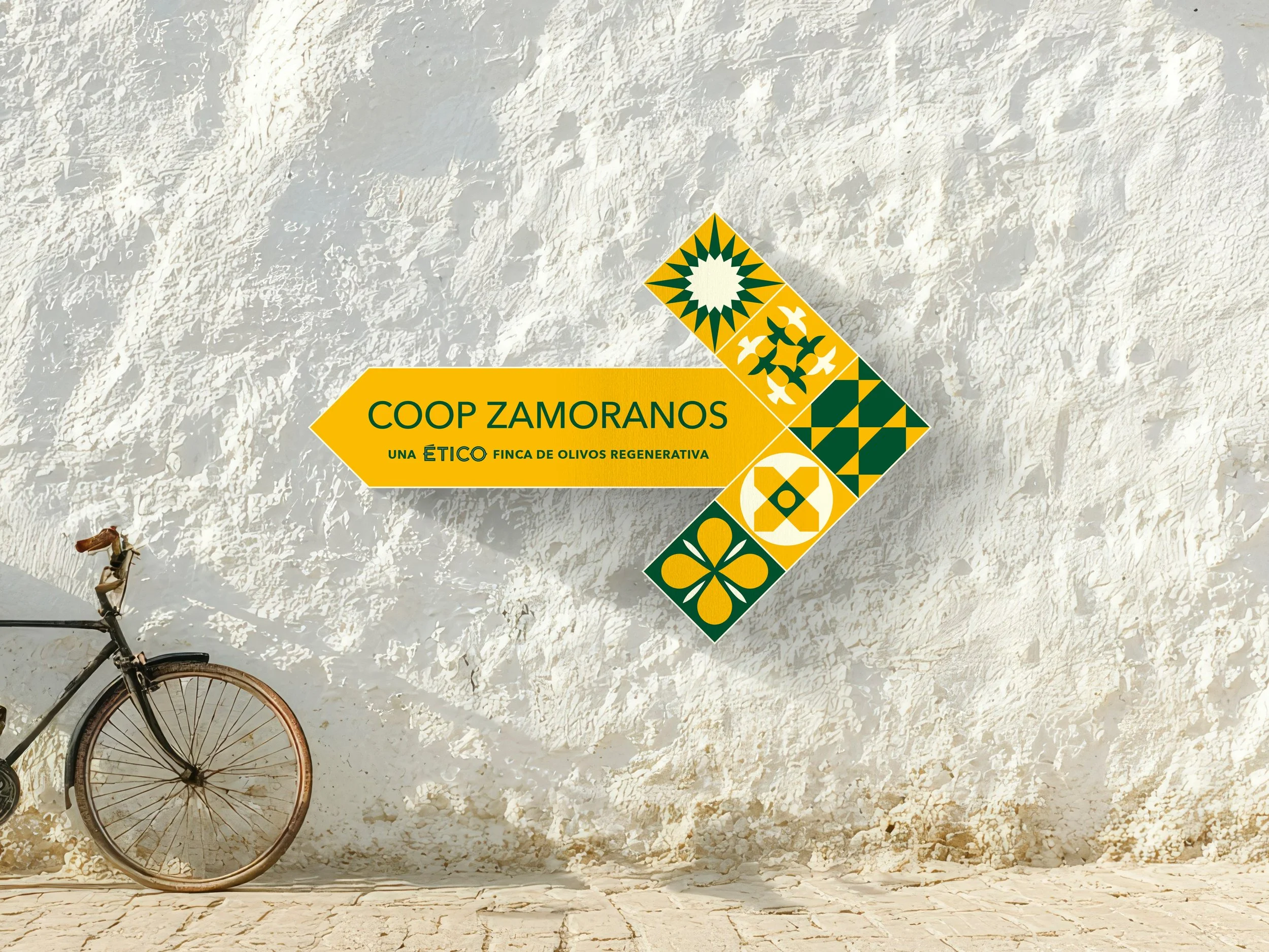 Proposed signage for one of Ético’s olive farms or fincas - taking the form of a yellow arrow with the Ético branding and tiles, sat on a white hand-plastered wall.