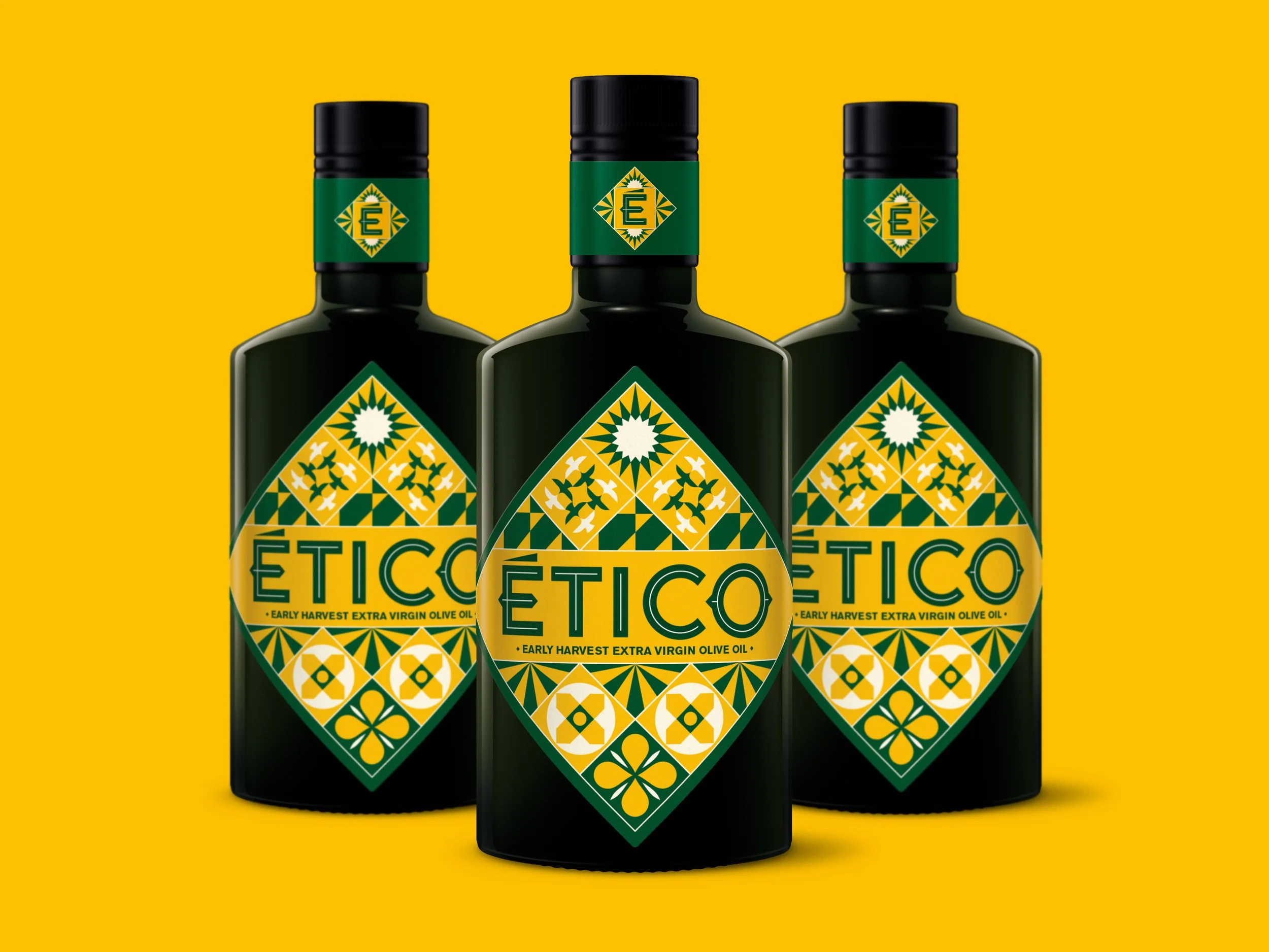 Three bottles of Ético Extra Virgin Olive Oil sat on a yellow background. The label features Moorish inspired tile patterns that tell the ethical story of the oil and it’s production.