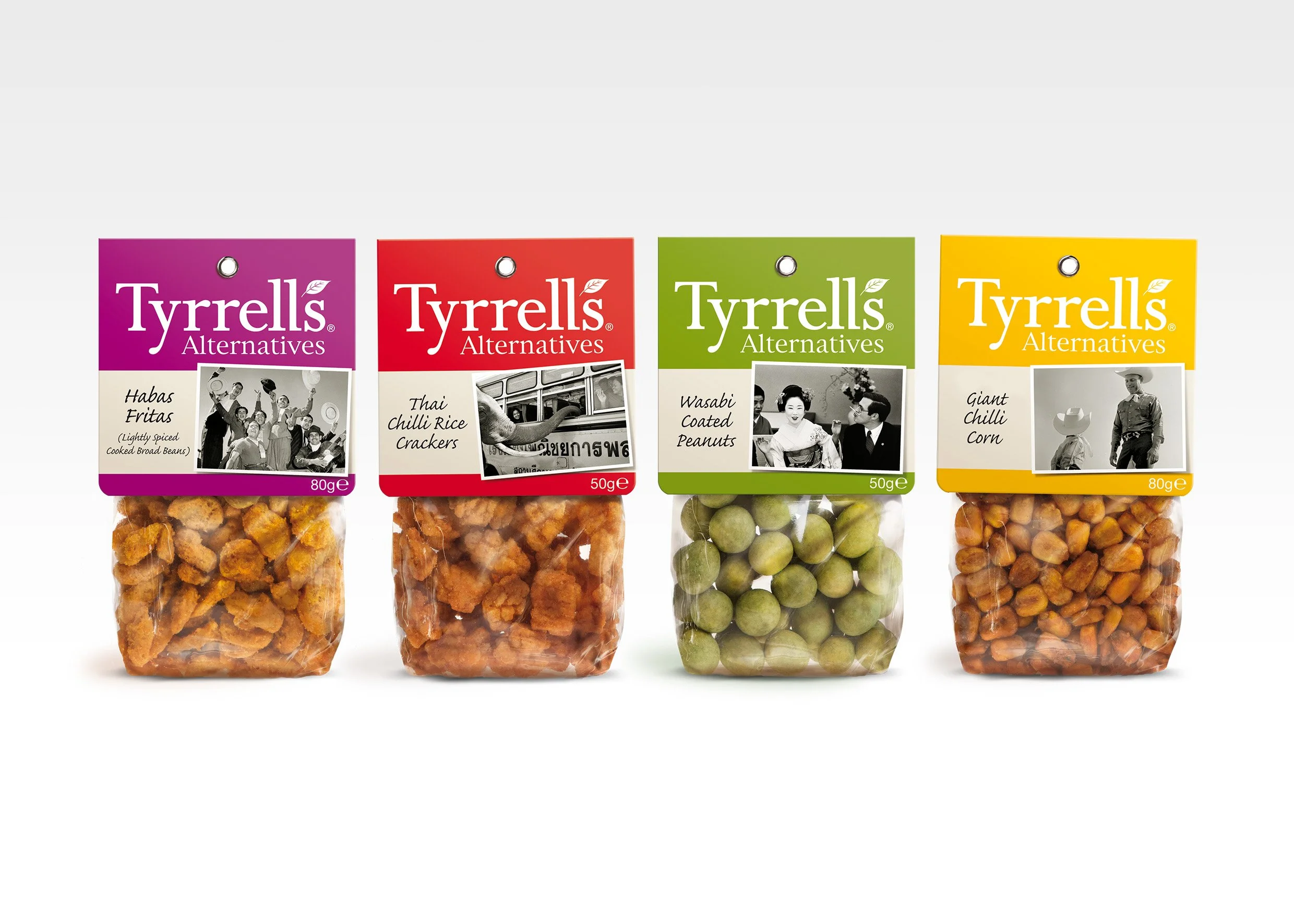 Four packages of Tyrrells Alternatives snack foods, including Habas Eritas, Thai Chilli Rice Crackers, Wasabi Coated Peanuts, and Giant Chilli Corn, arranged in a row.