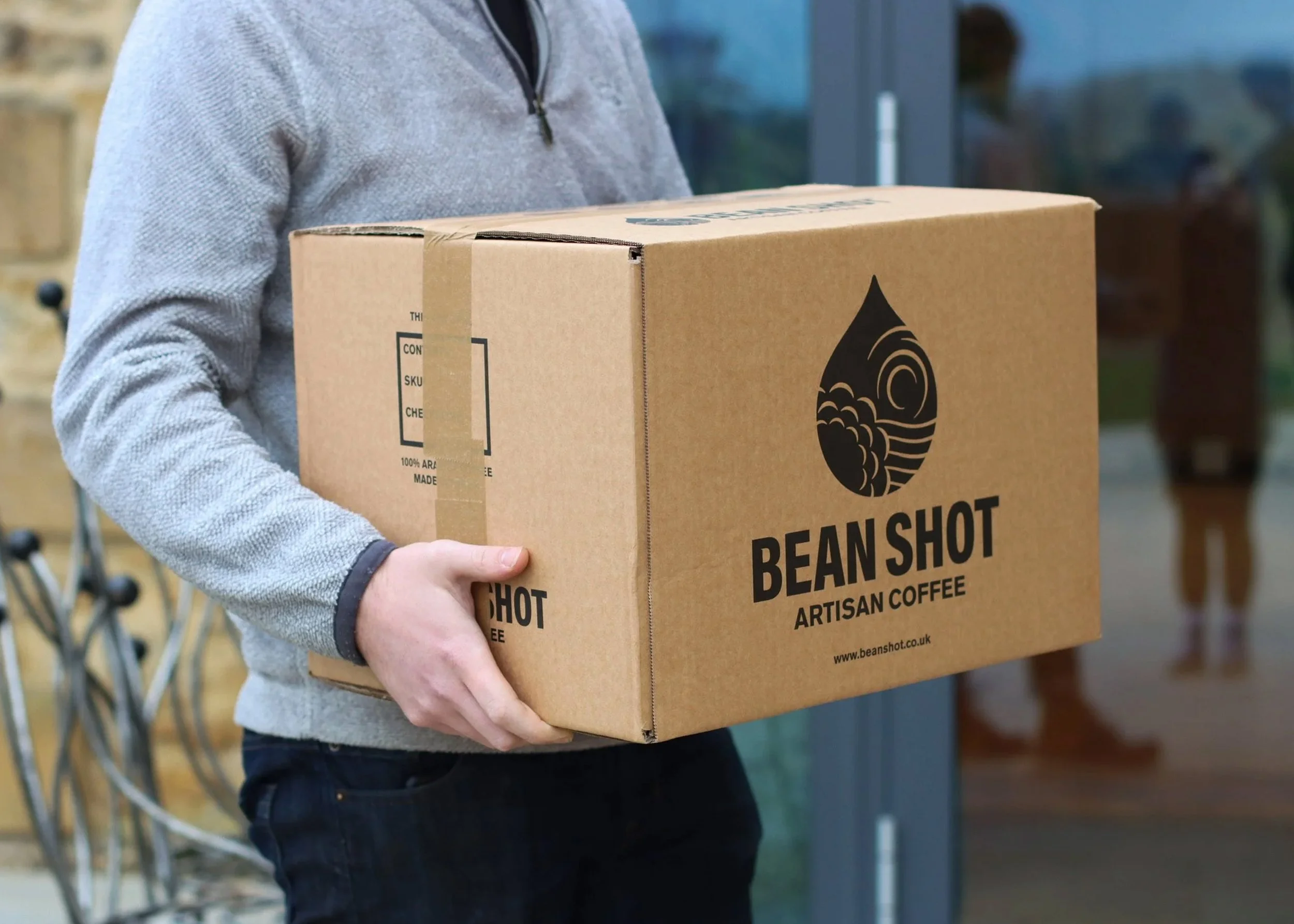 A shipping box with the Bean Shot Artisan Coffee Branding being taking to the shipping depot for export.