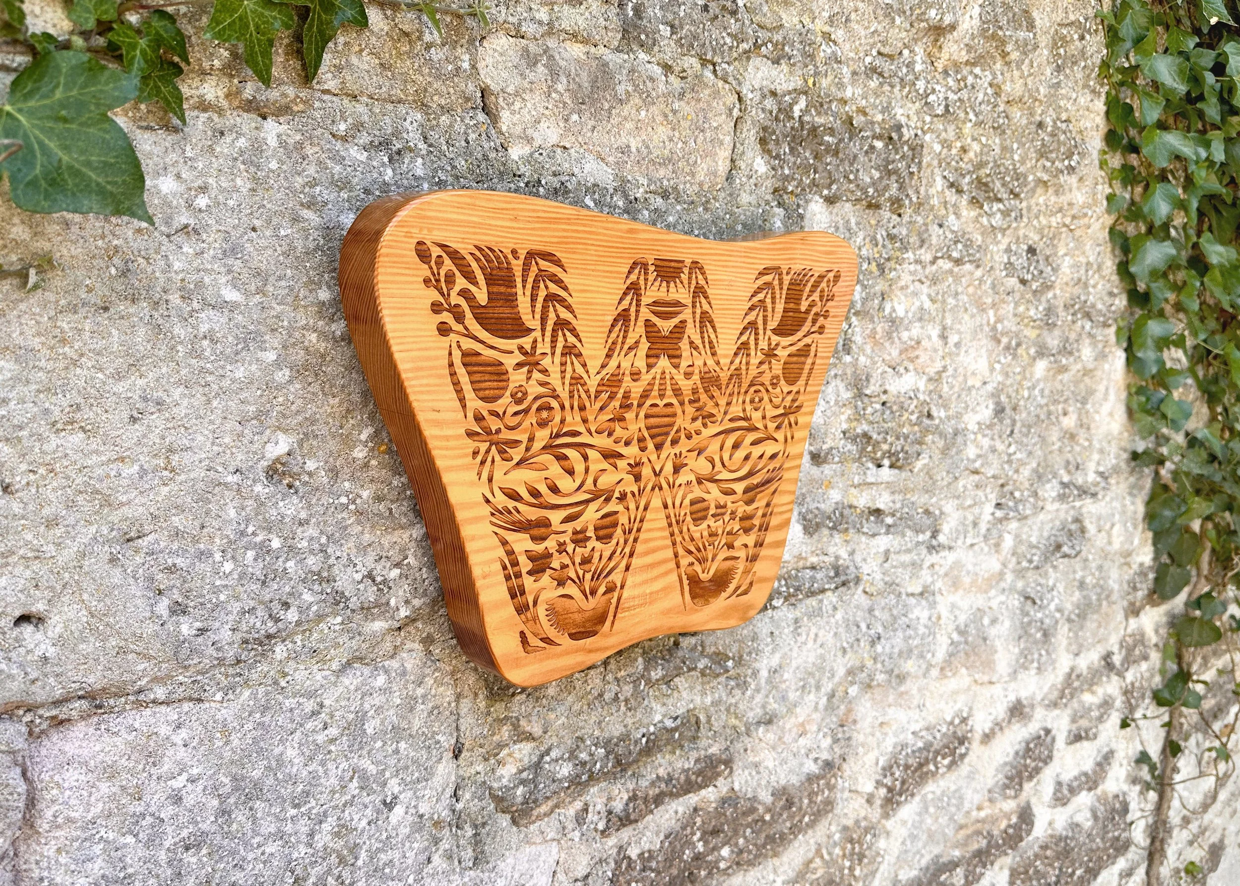 A handmade wooden sign with the Withywood brandmark lasercut into it.
