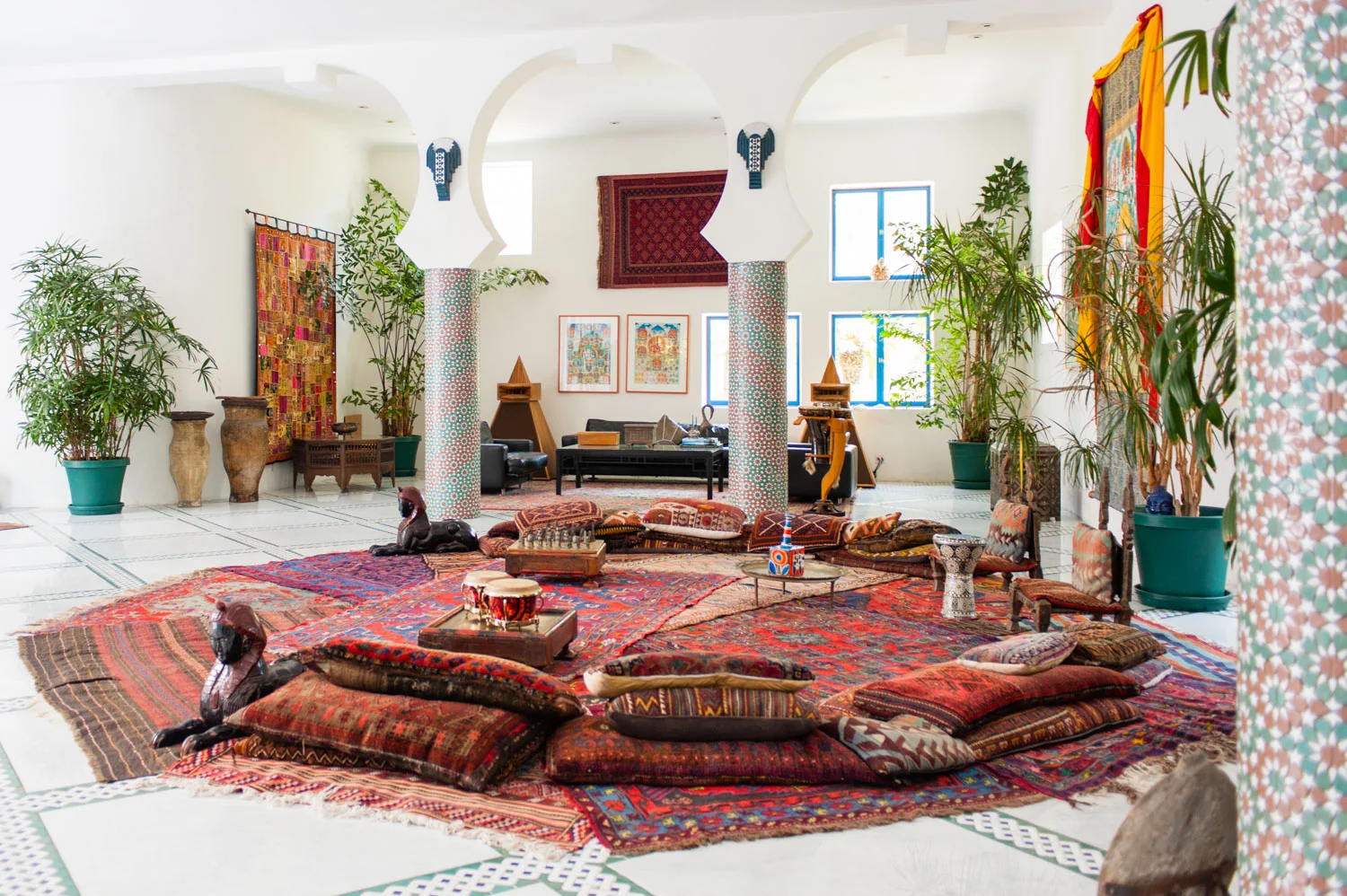 Turkish rugs and floor pillows in a room with archways.