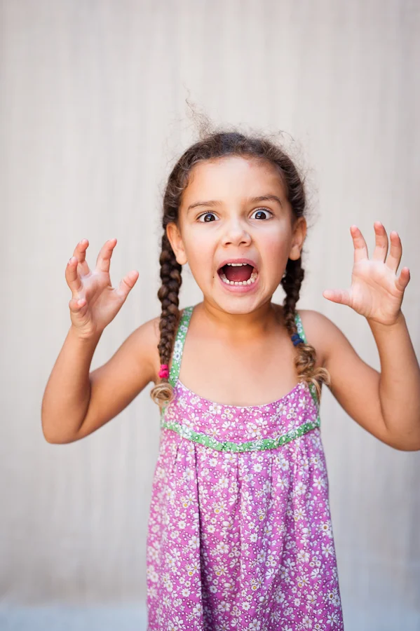 Girl with braids makes scary face.