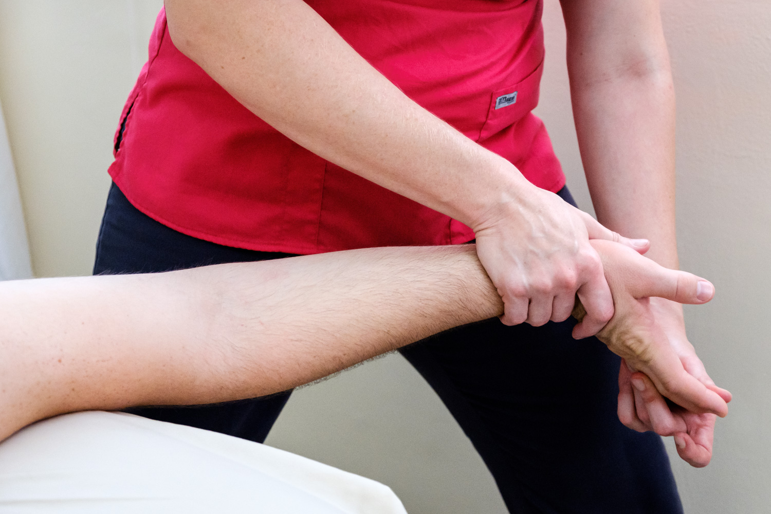  Female massage therapist stretching client’s hand. 