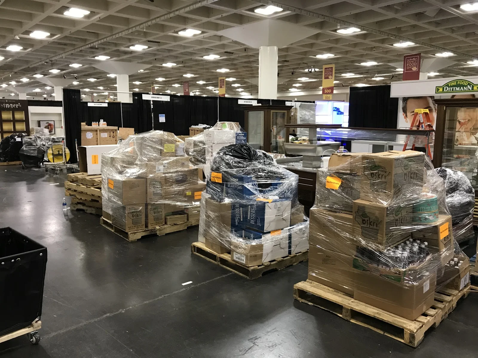 Recovered food stacked high on pallets on trade show floor awaiting delivery to recipient partner agency