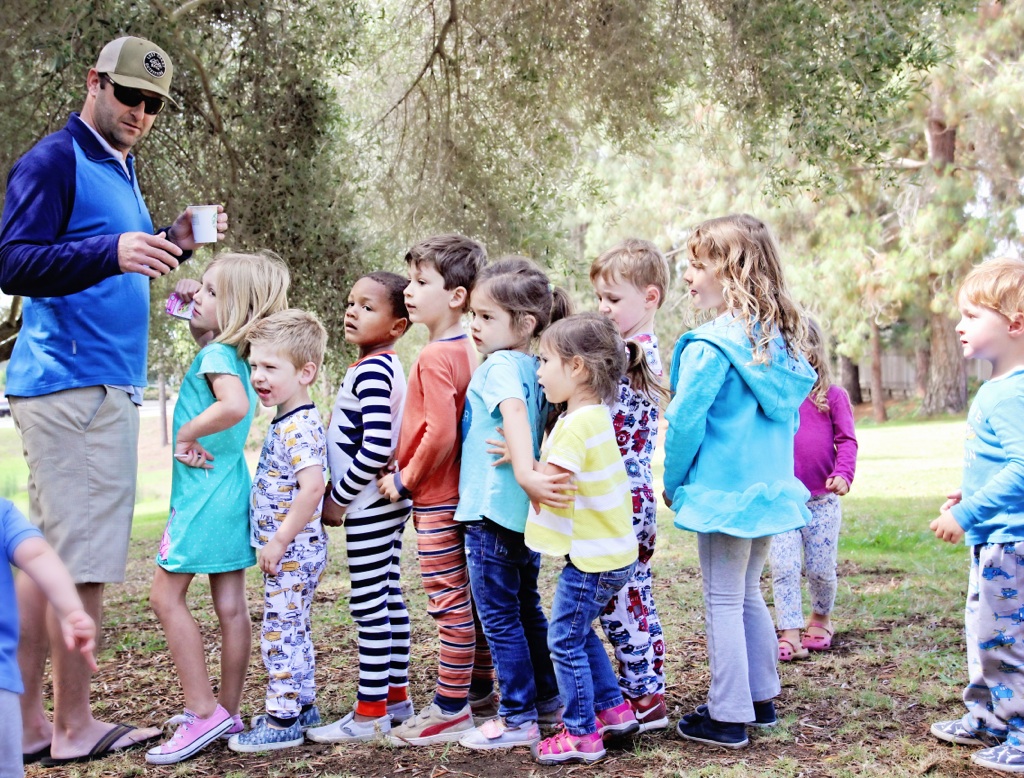 The kids lining up for the piñata. They came in their PJs, decorated donuts, ran around the park, and left high on sugar. (Oops.) I love Anna's little knee pop in this photo.