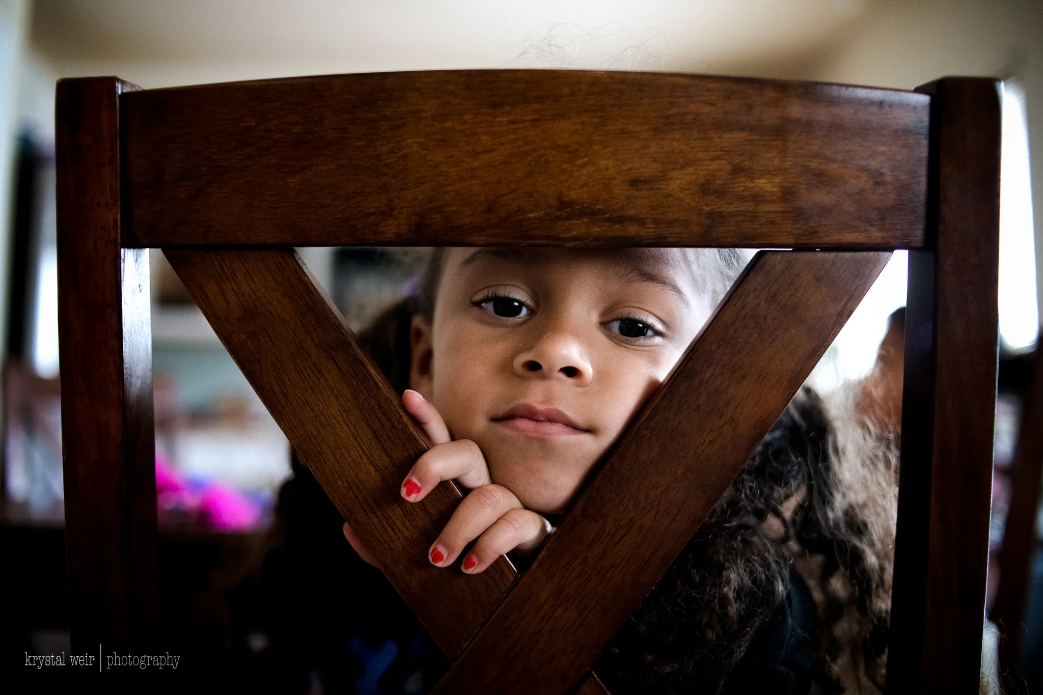 Day 3: Beautifully Framed Originally for this photo I was going for a details shot of her hand wrapped around the back of the chair and as I was photographing the hand she looked at me through the opening and it turned into this instead. I try to find different shooting perspectives so that I am not photographing the same thing everyday even though I may be photographing the same subject, so with a little help from my girl this photo turned into something more than I was trying to achieve. 