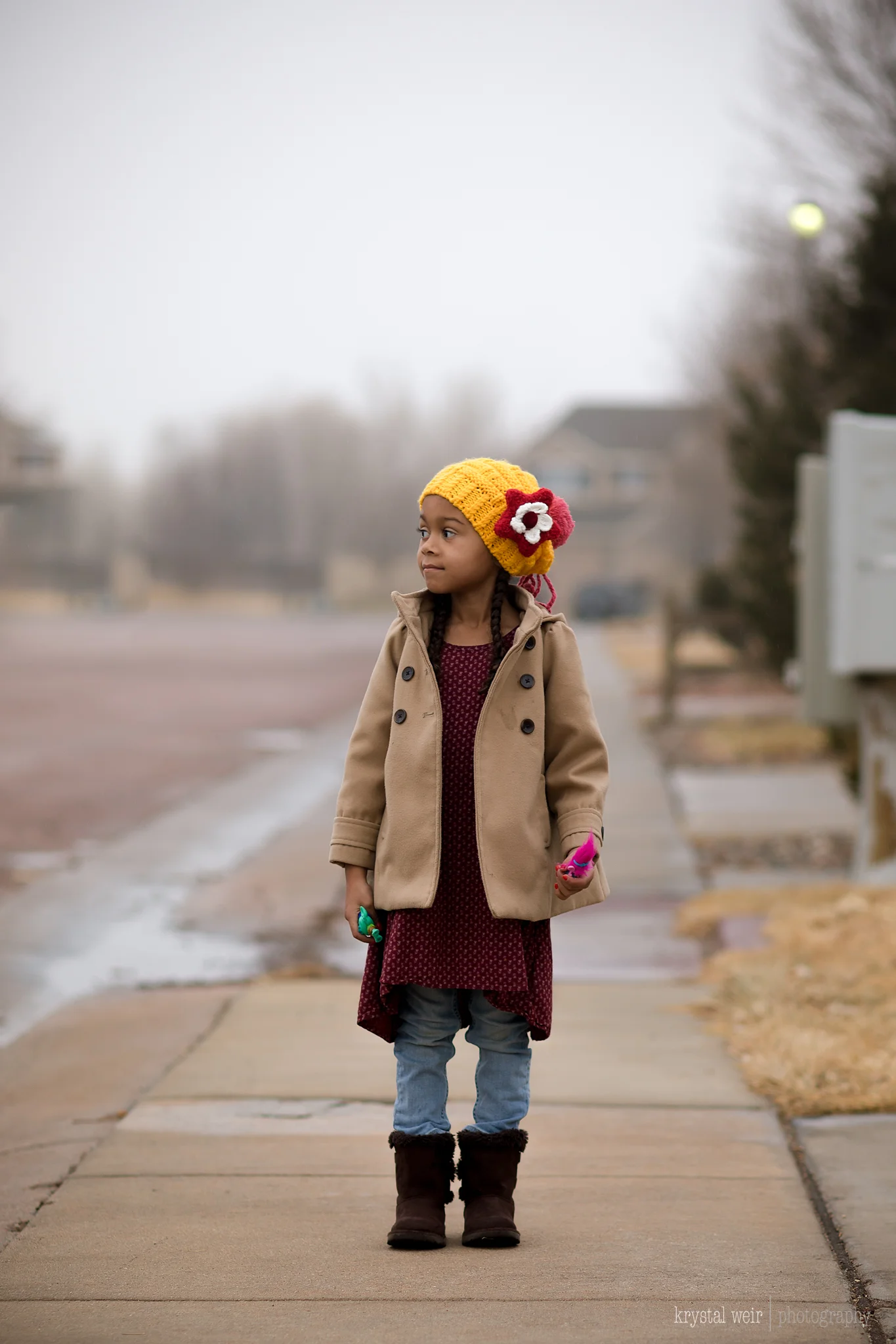 Day 15/365 It was so gloomy today, but we did get out of the house at least once This day was a lazy Sunday until about 3pm when I decided to get out of the house and the kiddos wanted to tag along too. I hadn't picked up my camera all day so I decided to get a shot of my girl in her cute little outfit before we headed out. I usually like a cloudy day for photographs because it gives off a diffused light source because dealing with harsh sunlight can be a pain in the butt. I think her little hat made this photo not only because it's cute, but because it added a pop of color to a very one toned, gray image . 