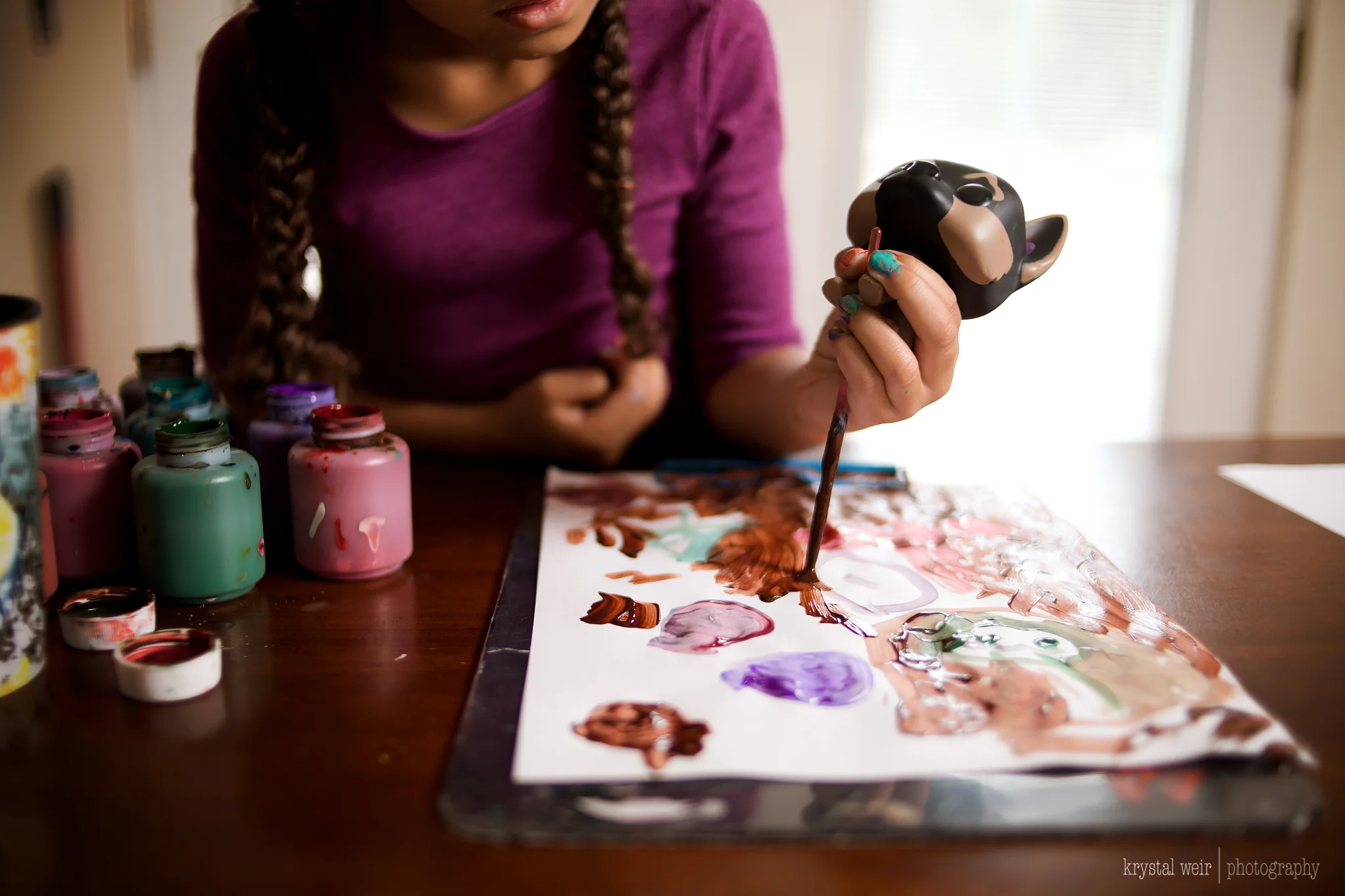Day 24/365 Today we painted I still had the faceless theme in my mind for this shot as well. I wanted to focus on her hand and the brush, but also have a hint of her face in the frame. I used my lighting equipment for this image. I had it about 5 or 6 ft away from her, above her and pointed down. The lighting gave me beautiful depth to this everyday photo, nIce shadows and highlights. 
