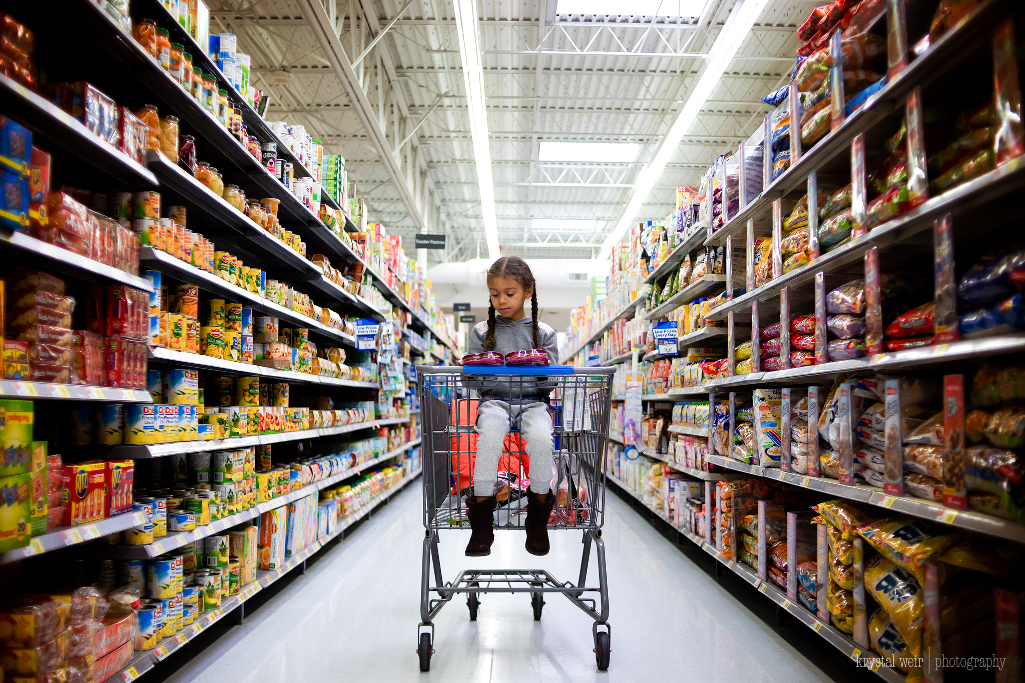 Day 25/365 Today we shopped Leading lines are a great way to add dimension to a photo. If you know Walmart, it's usually full of people so to get an aisle to yourself is rare. I took advantage to get an interesting shot. She was centered in the aisle and I squat down to get at an even level with her and the lines lead your eye to the subject perfectly. 