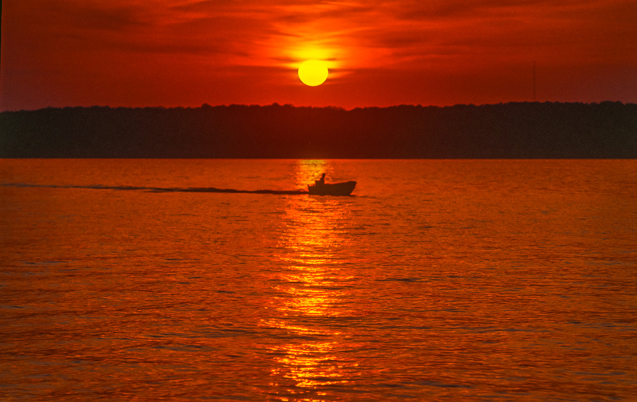 Fisherman Motors Home Under Red Sunset