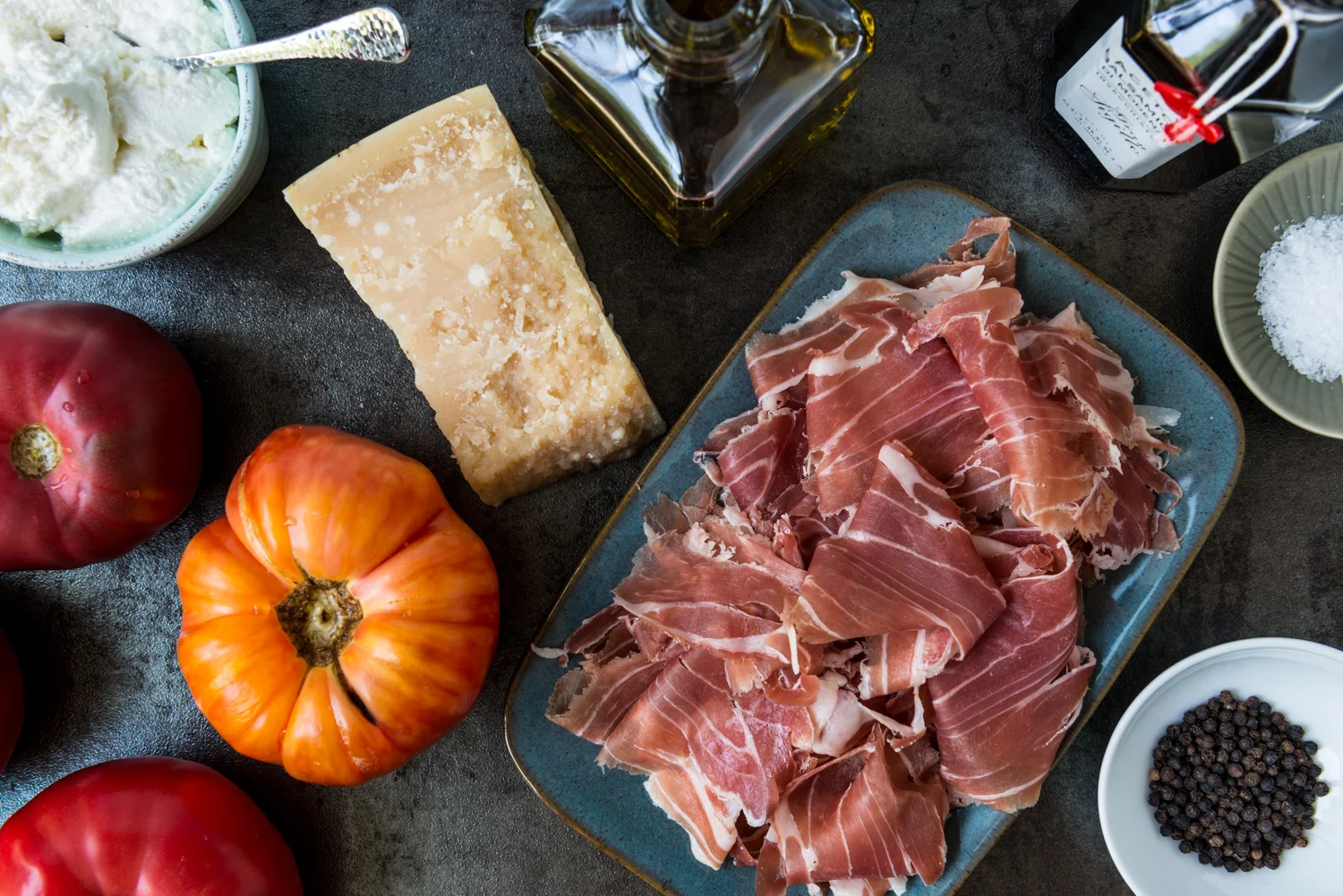 Mise en place: Fresh, local hierloom tomatoes, Prosciutto di Parma, Parmigiano-Reggiano, ricotta, Aceto Balsamico di Modena from Lambrusco producer Cleto Chiarli, olive oil, good quality flake sea salt, black pepper