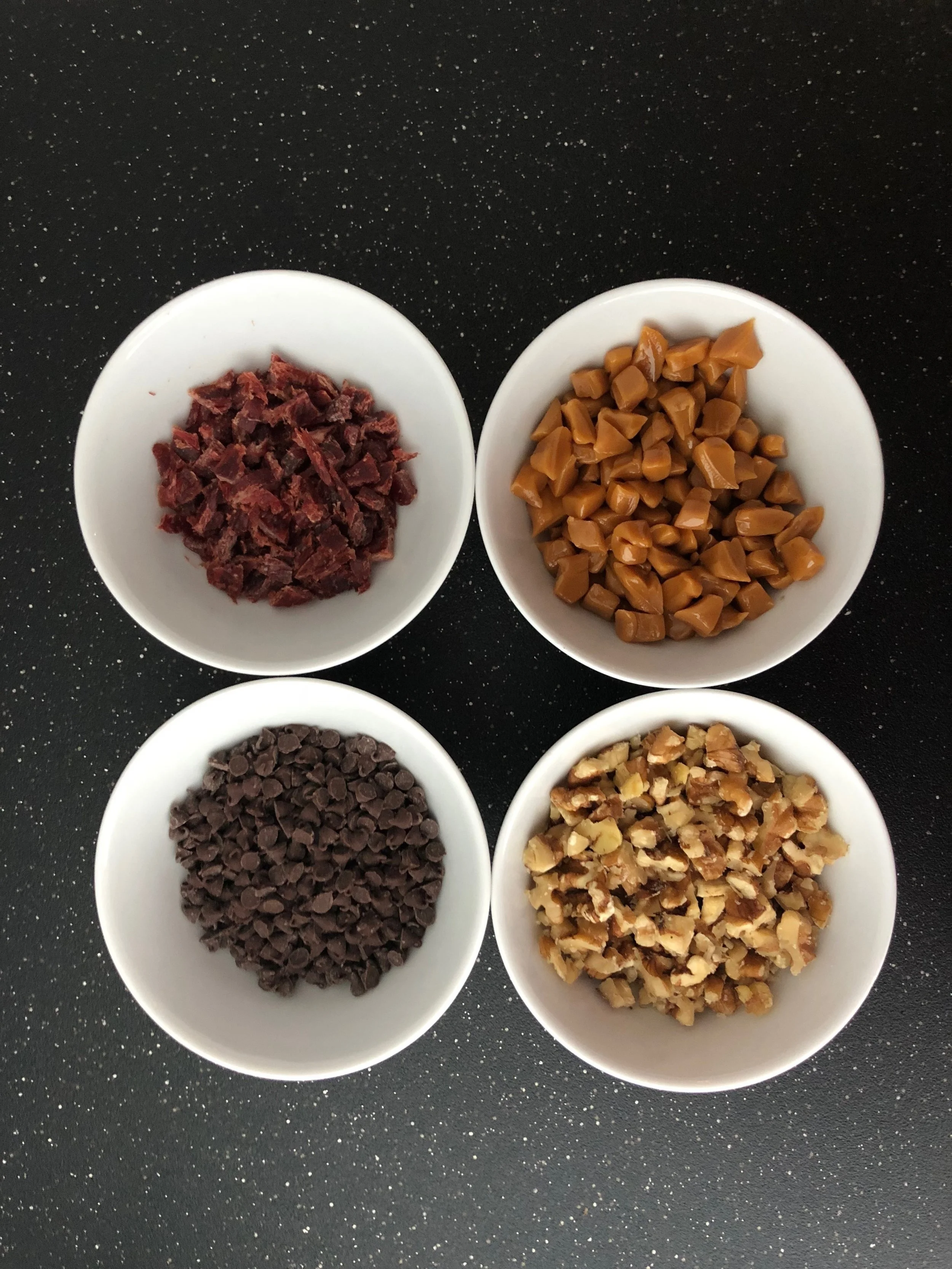 Clockwise from top left: beef jerky, caramels, walnuts, and mini morsels.