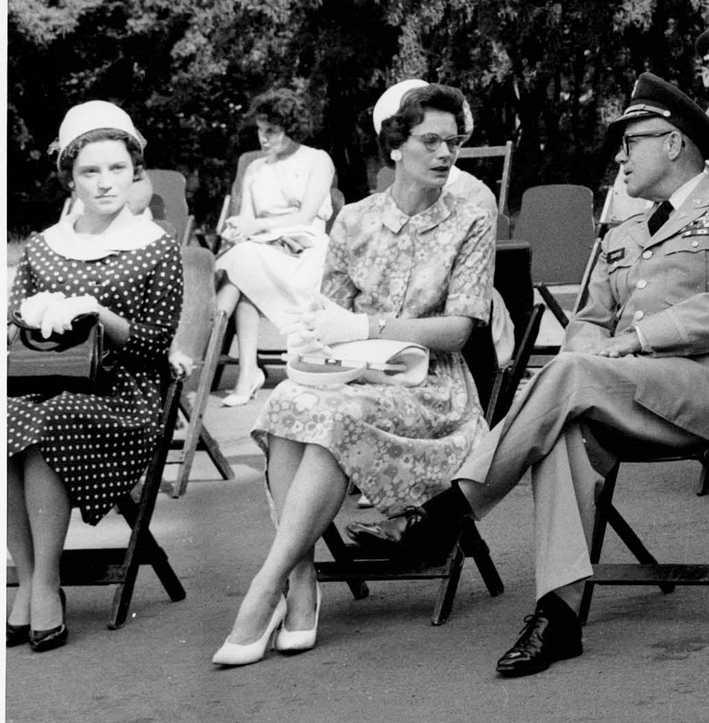 The author’s mother, wearing glasses and proper attire, at a public event.