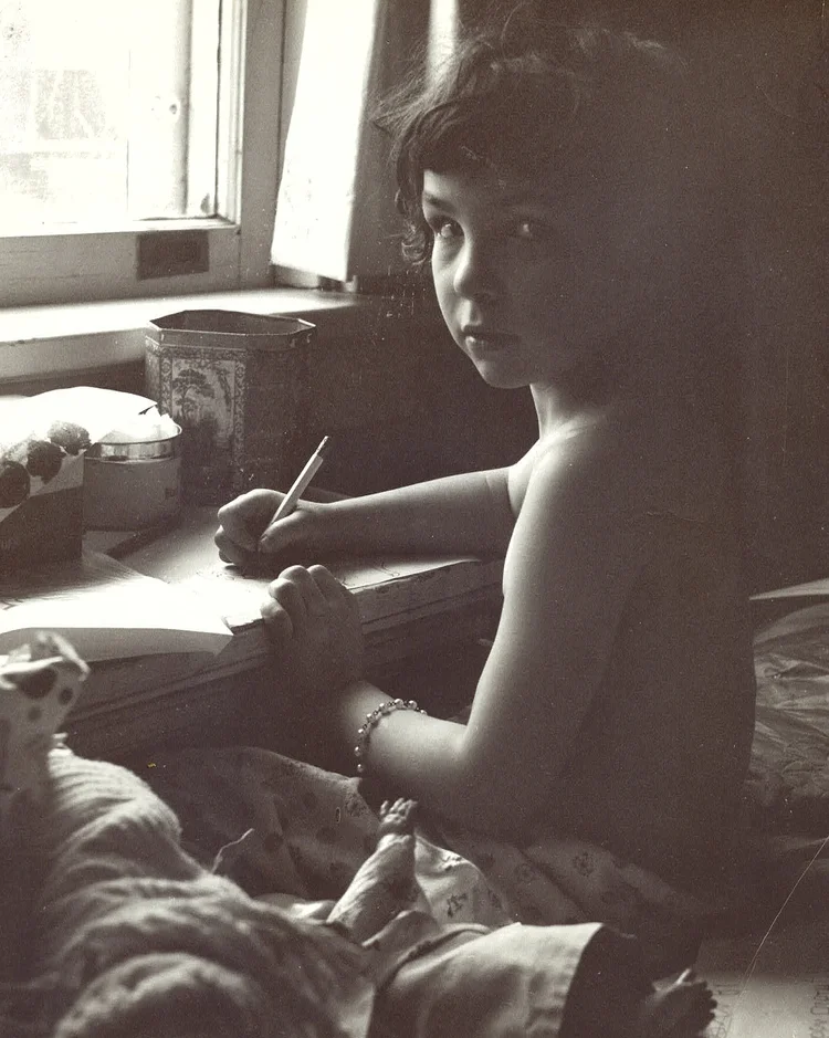 Maybe four years old doing what makes me happiest. Sitting at the window drawing.