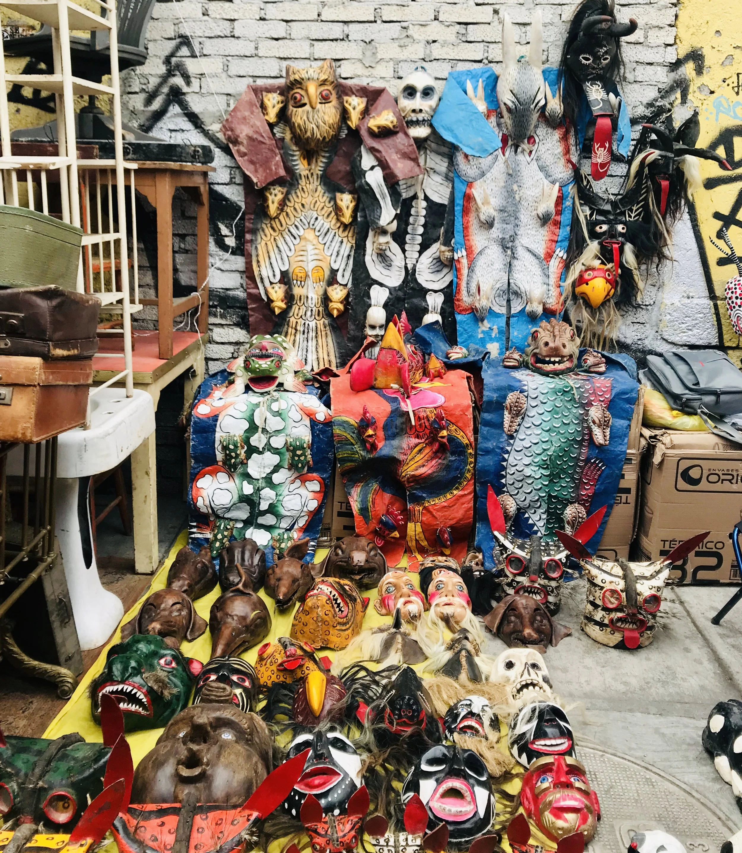 The outdoor area where the antiques are spread out has graffitied walls behind it.