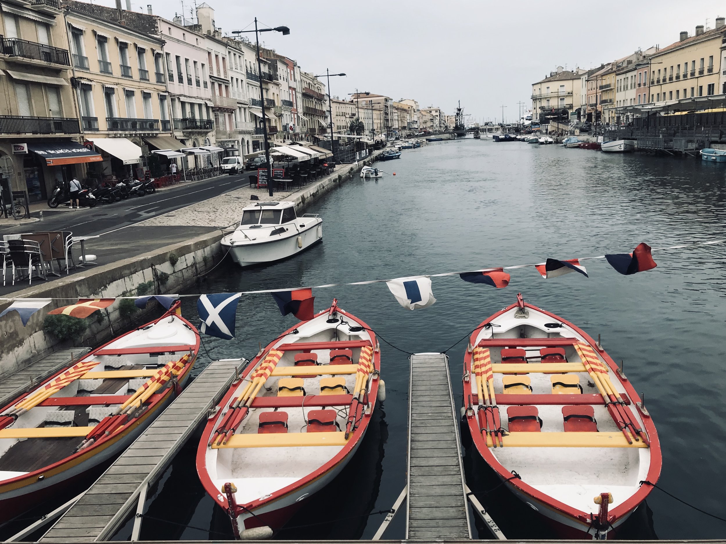 One of the scenic views of a Sete canal with colorful touring boats.