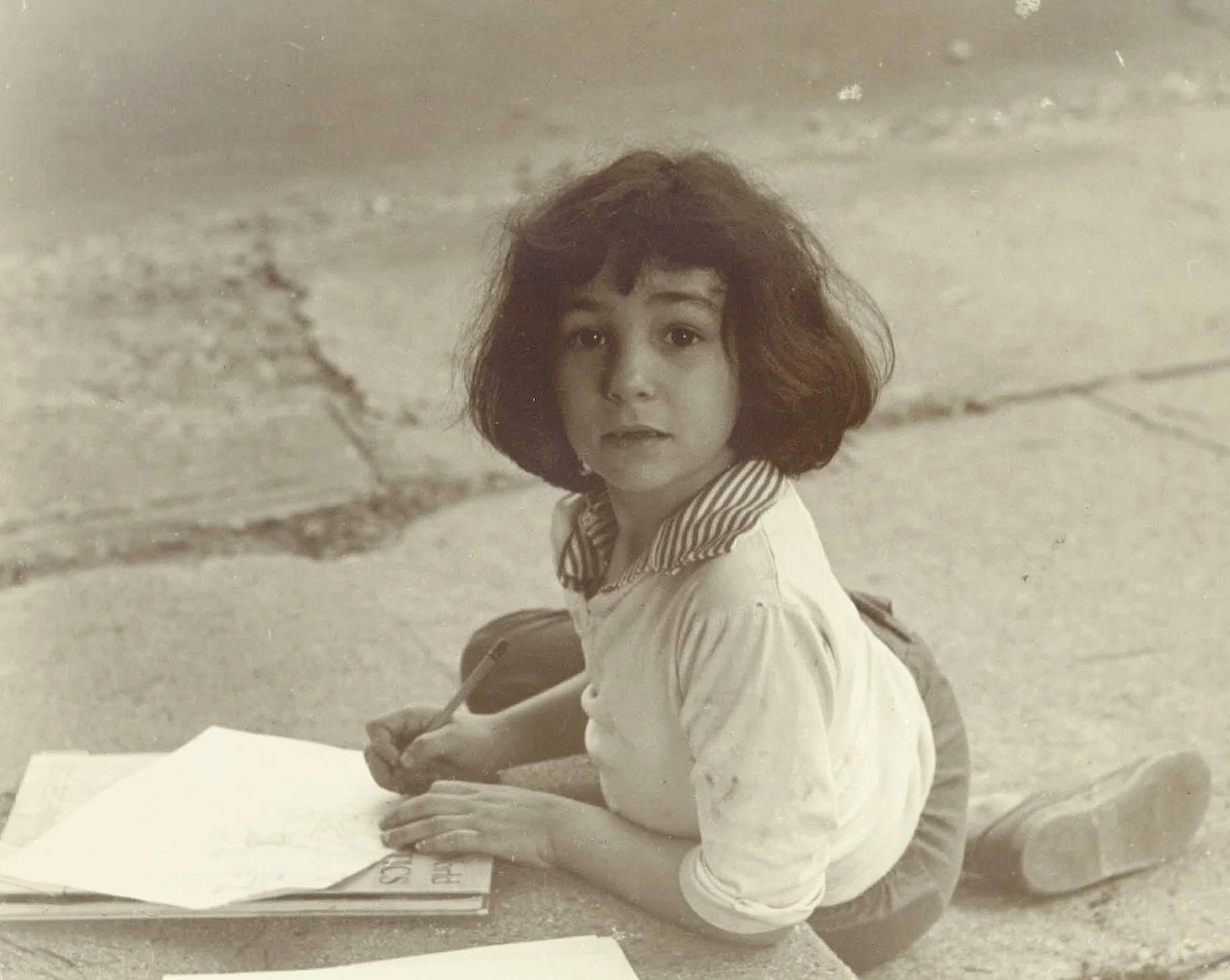 Old photo of me drawing in front of our house.