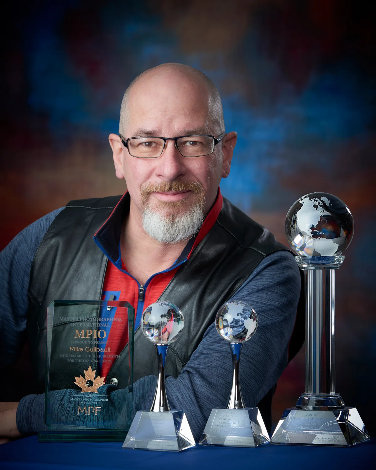 Mike Guilbault shown with (from left to right) the Master Photographer in Fine Art Award, the Best in Class (Seascape), Best in Class (Landscape) and the 2016 Nature Photographer of the Year awards from MPIO.