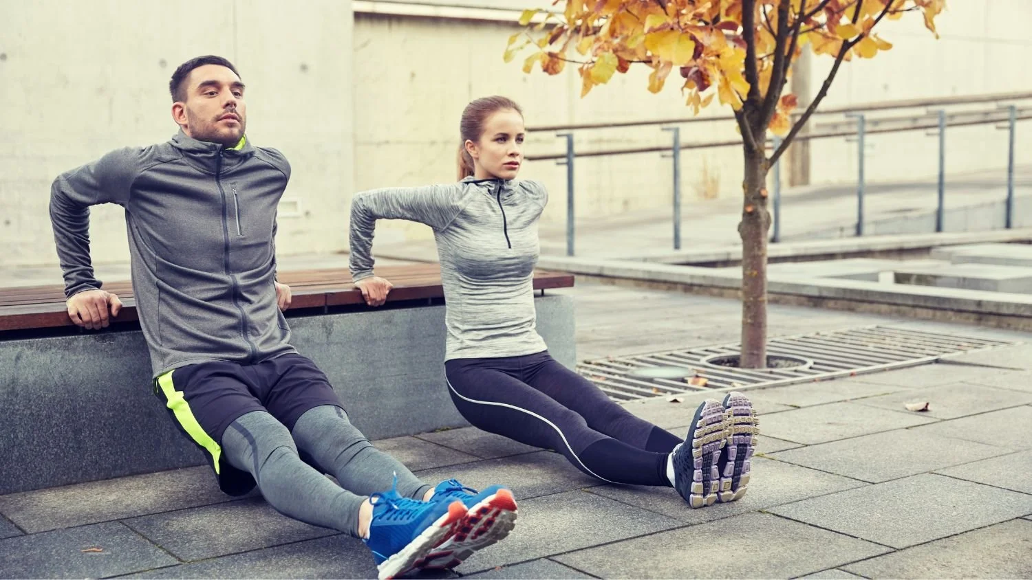 man and woman doing dips on a bench outdoors