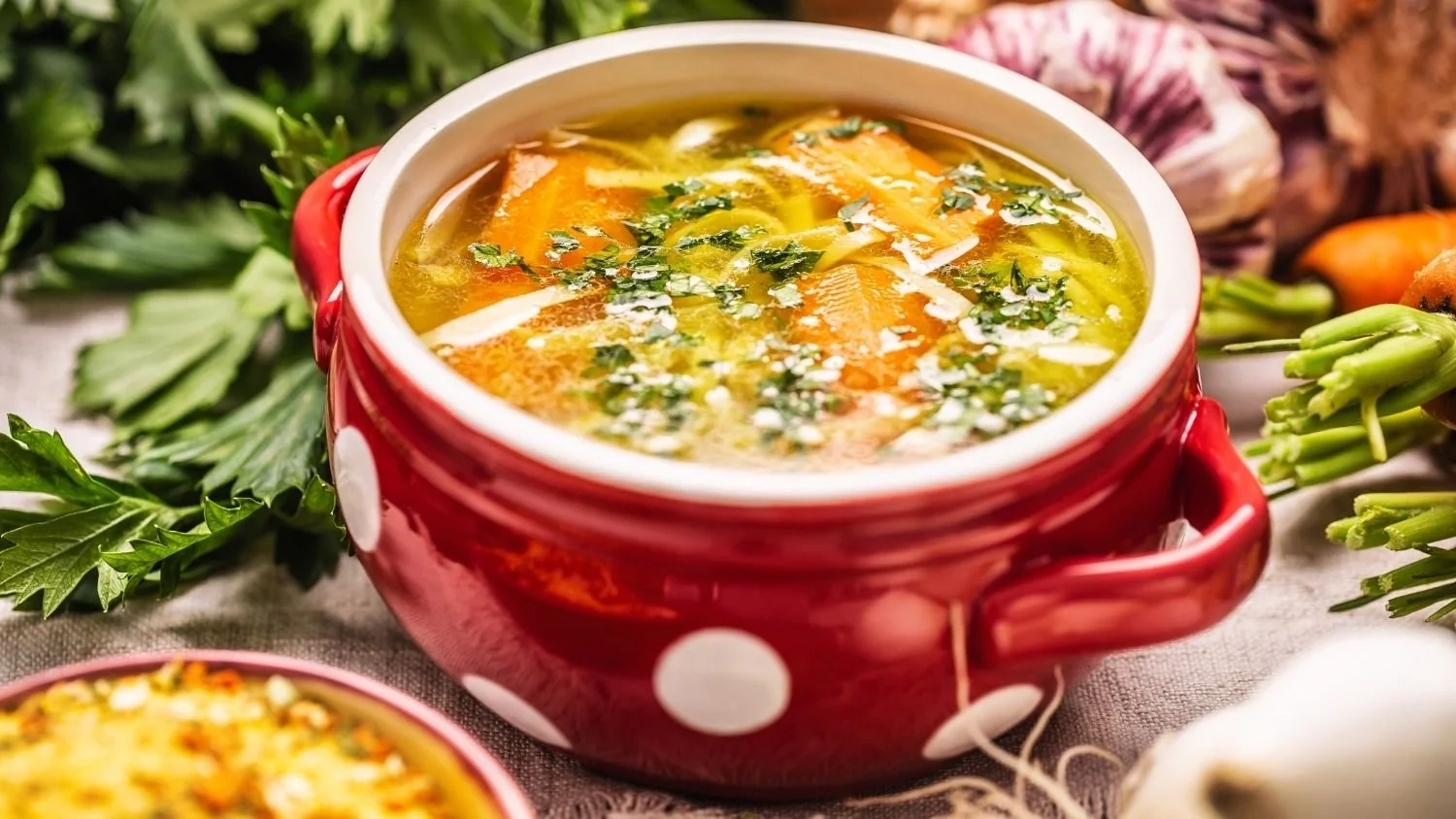 comforting vegetable soup in a red bowl