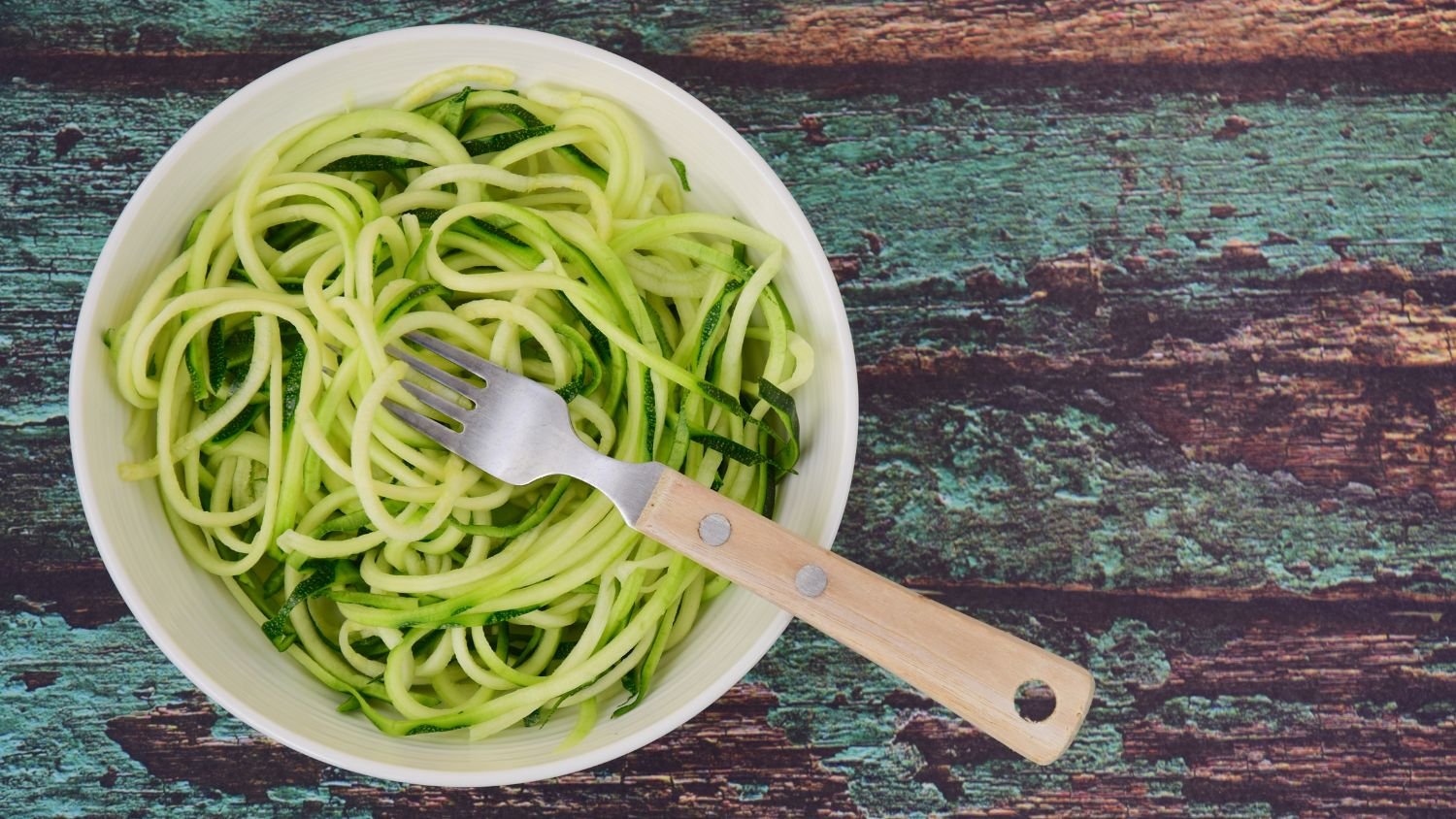 zoodles in a white bowl with a fork