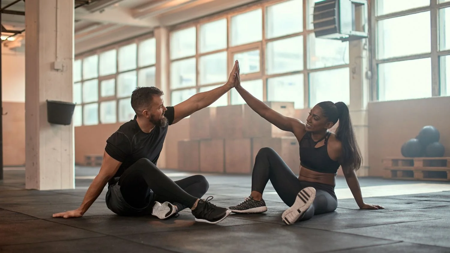 man and woman high fiving in the gym after a partner tabata workout