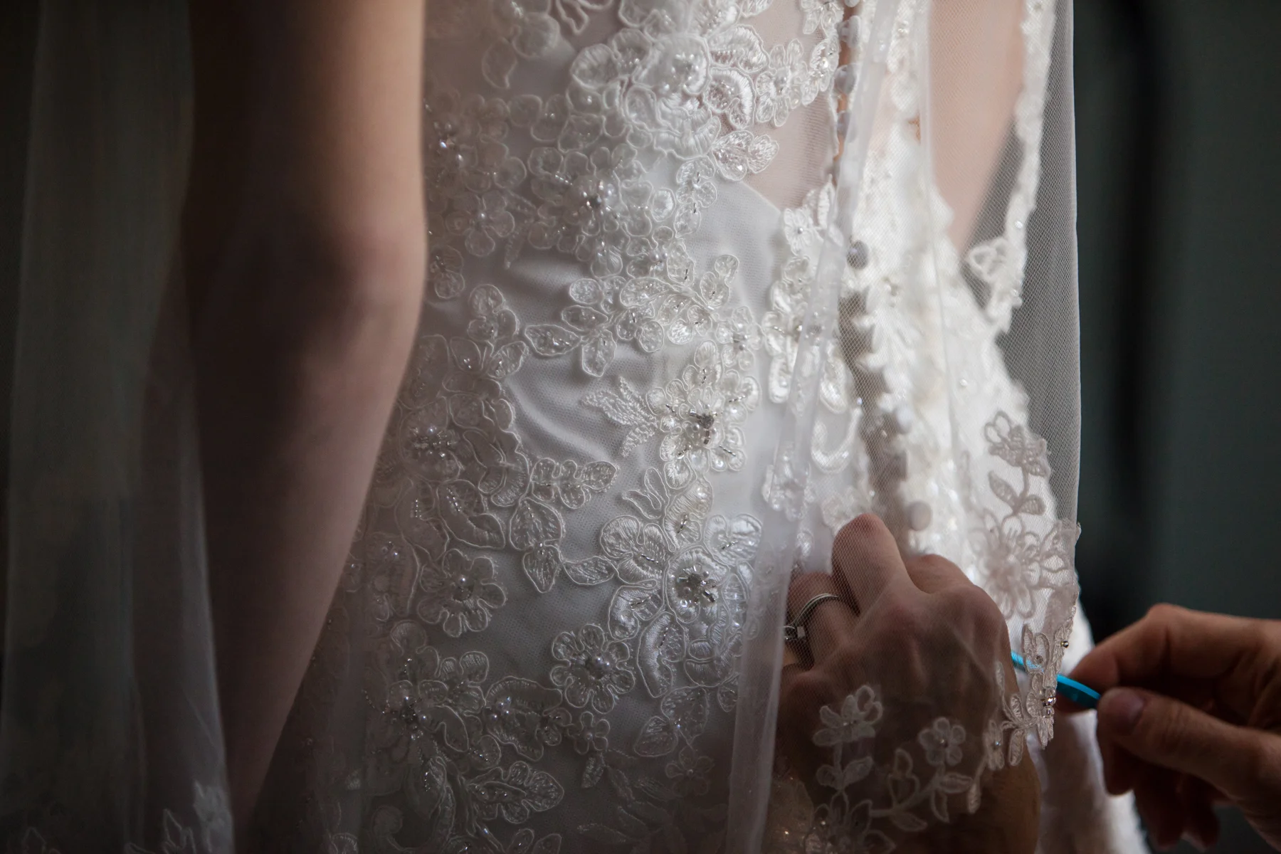 It is always such a beautiful and emotional moment when a bride steps into her dress on her wedding day. Kayli's dress had such beautiful lace and beading detail and the look of a button up back on a wedding dress is always so elegant. Her mom helped her get all of those tiny buttons hooked and of course a crochet hook is a nice thing to have to make the process a little easier :)