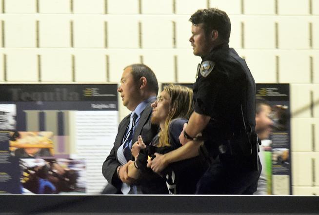 Police apprehend a protestor as the Dalai Lama spoke during the afternoon session Thursday at the University of Colorado campus in Boulder. ( Jeremy Papasso / Staff Photographer )