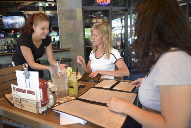 Dominique McKee delivers chips and salsa to Debbie Balsley, center, and Christine Wright at the Pumphouse Brewery & Restaurant, 540 Main St., Friday afternoon. ( Lewis Geyer / Staff Photographer )