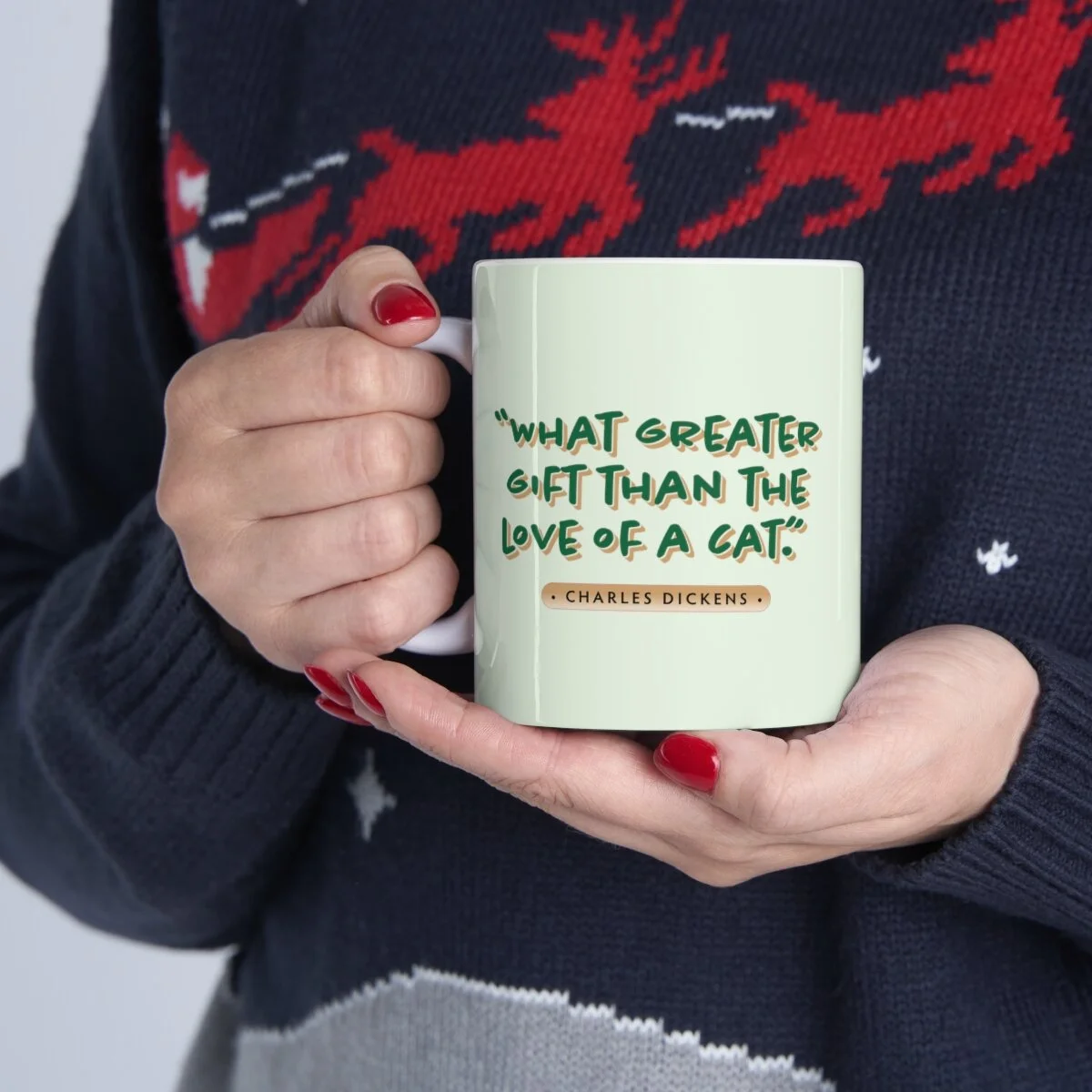 Christmas cat mug in hand with message, "What Greater Gift than the Love of a Cat."