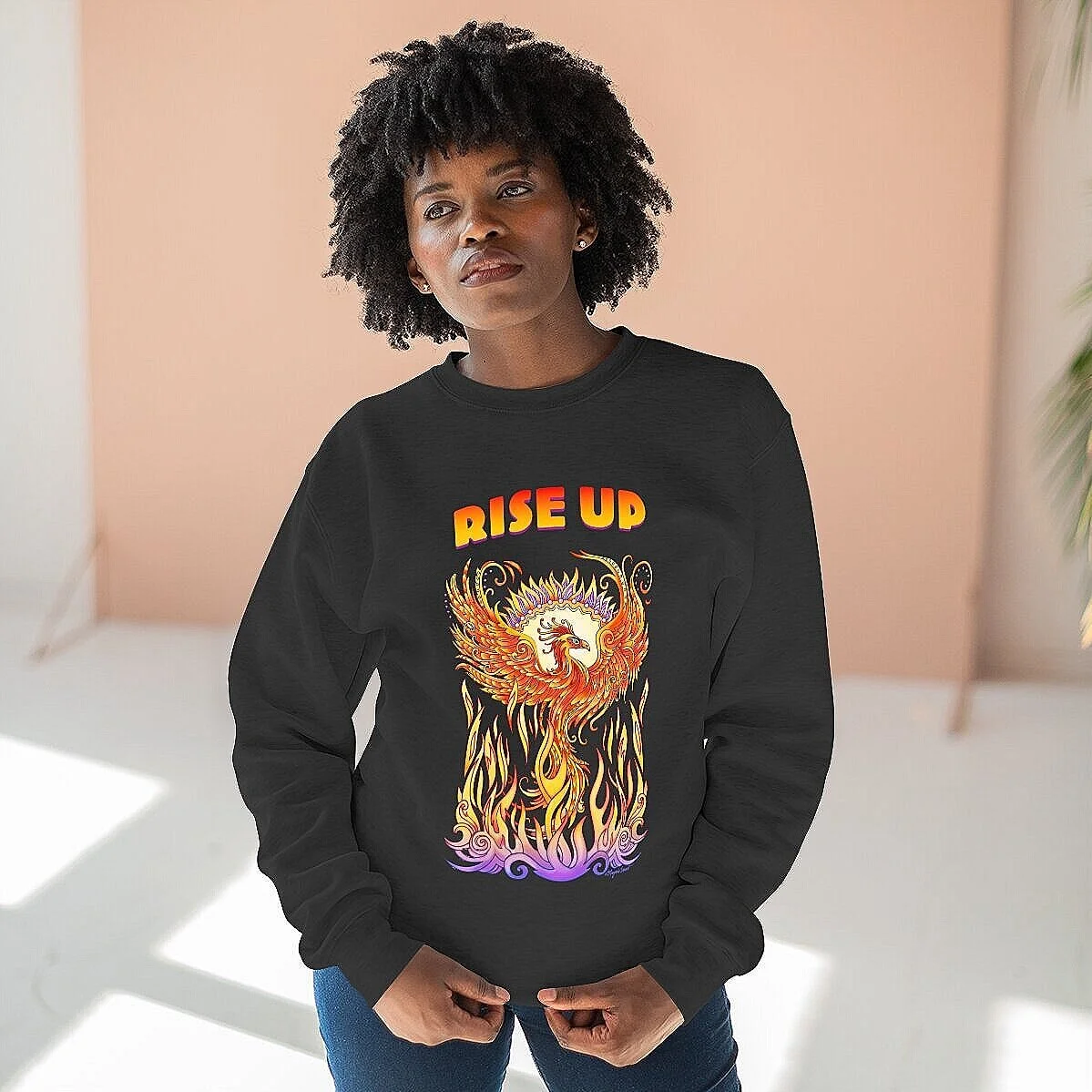 Woman wearing sweatshirt, with wording Rise Up and artwork of phoenix rising from flames