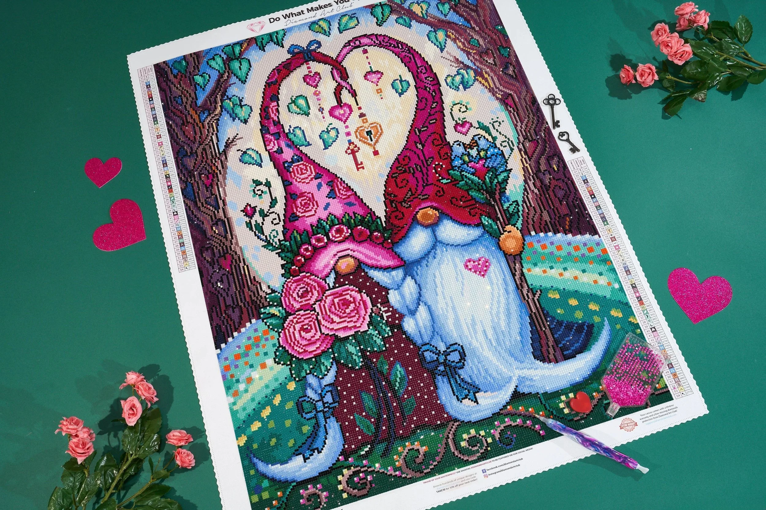 A diamond art painting of a gnome holding a rose bouquet, with a heart-shaped head, surrounded by trees and flowers, on a green background with hearts and pink roses.