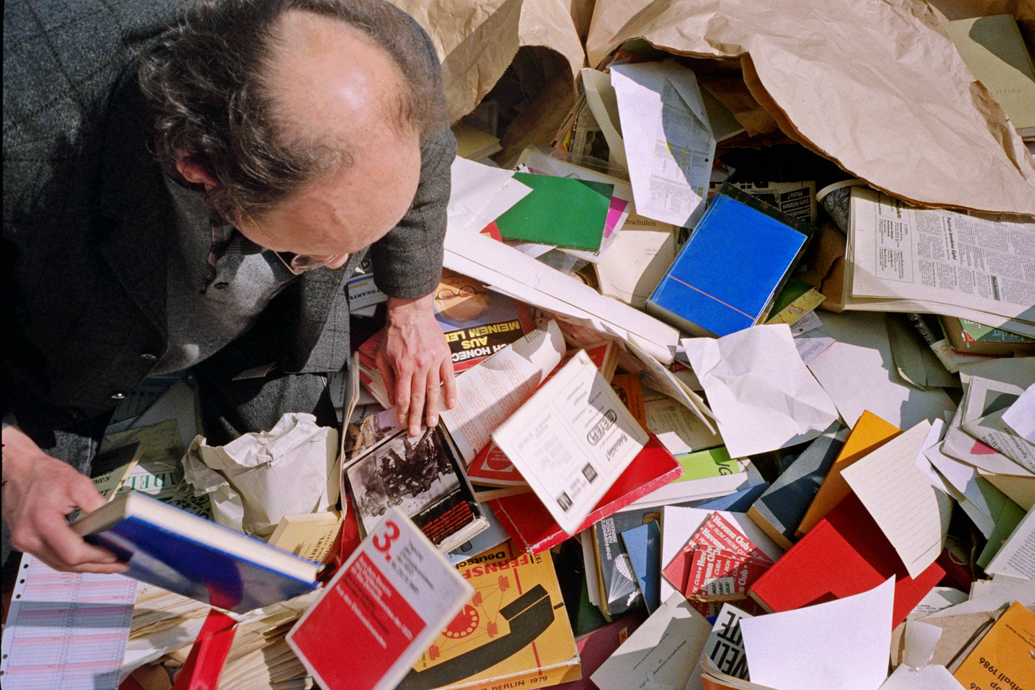  My friend David was a "junk remover" permitted onto the Stasi headquarters at 15 Normanenstrasse and I accompanied him as an assistant with a camera. This image shows David knee deep in a dumpster full of bureaucratic junk, forms, photographs and a 