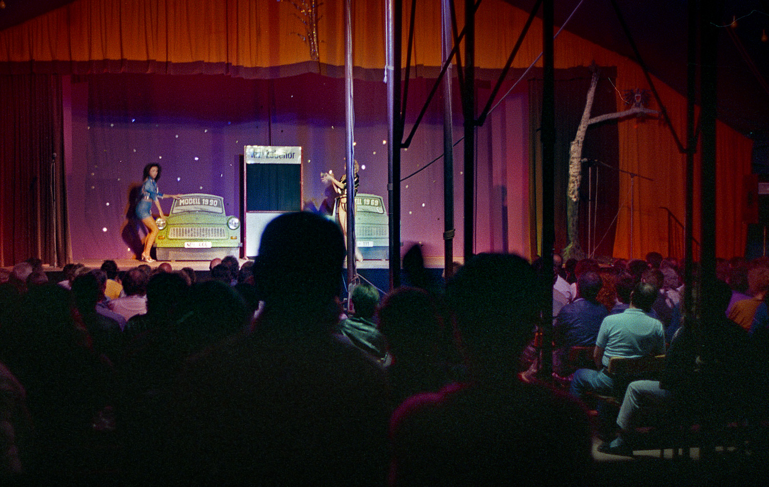  A satirical burlesque comedy show in a tent near the Sport Stadion. The skit was based on the 1990 Trabi versus the 1969 Trabi - lots of new features eh? Exactly the same car- but that is progress in the DDR - that was the joke. Dark in there. Berli