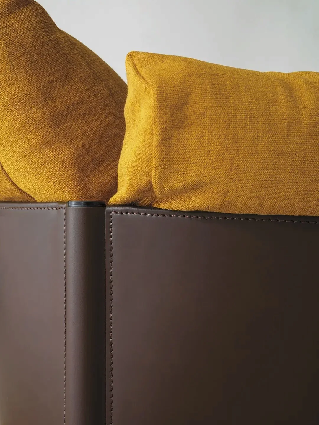 Contemporary lines, timeless inspiration &ndash; a design that speaks through its details.

A sleek tubular frame embraces generous leather bands, cradling voluminous cushions that invite you to sink in. Movable back and armrest pillows adapt to your