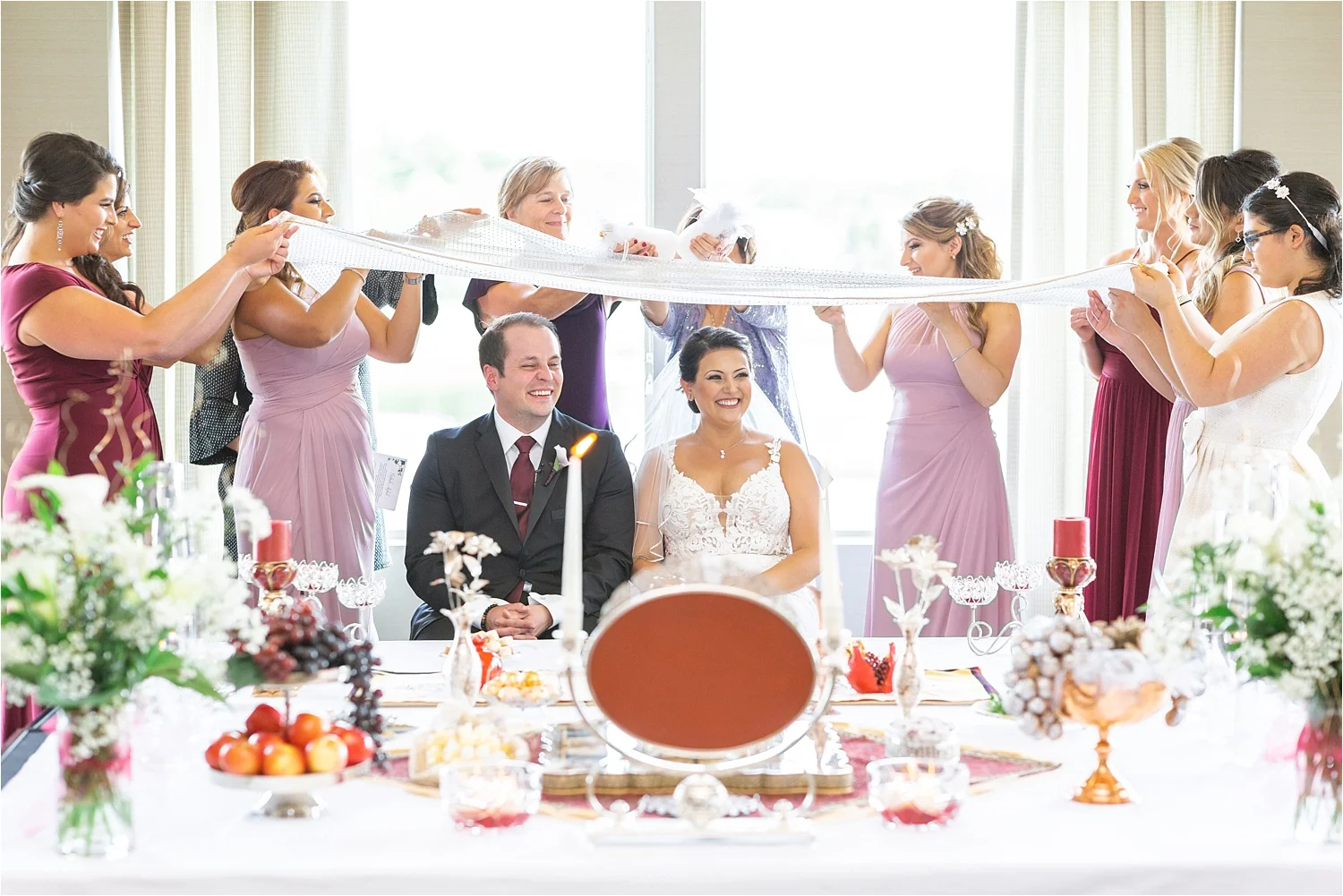 Persian Aghd ceremony with family holding the ceremonial cloth above the seated bride and groom