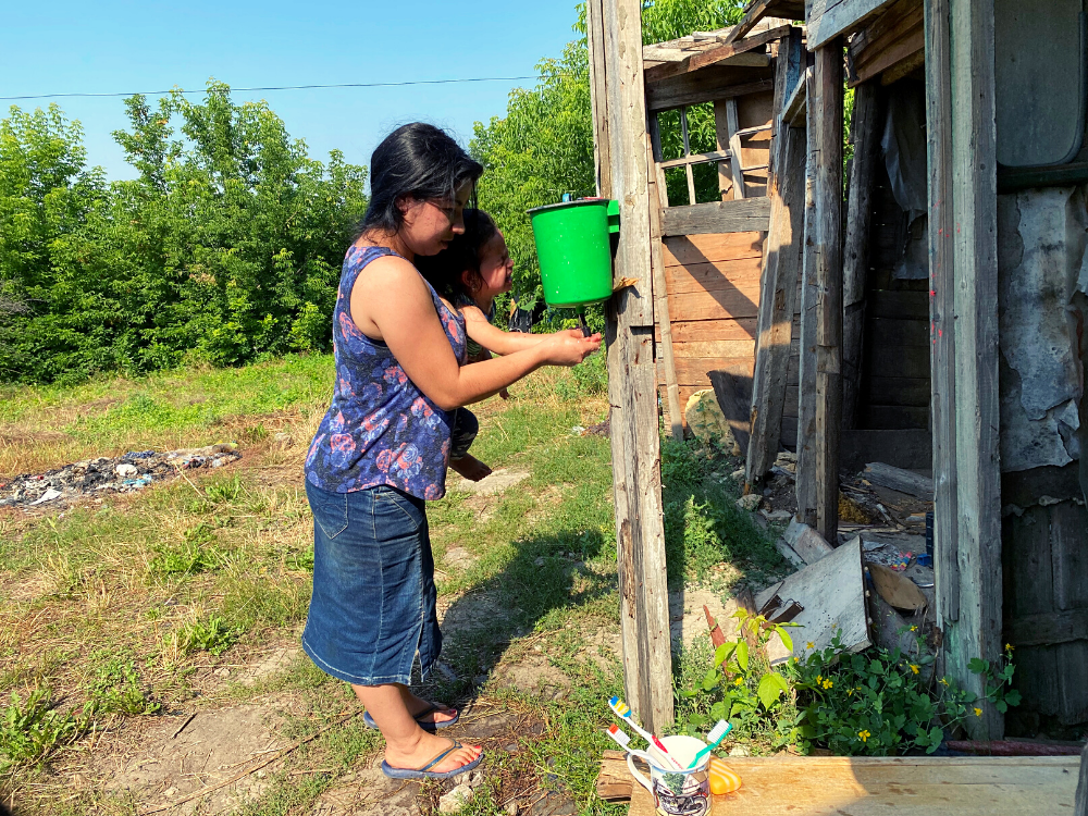  Volodymyr’s daughter washes her hands in the family’s outdoor washroom, which uses water drawn from the handpump well in front of the church. 