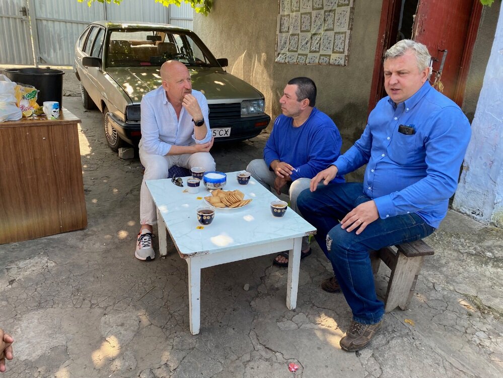  Global Action Director of Europe, Igor Grishajev (left), has tea with Volodymyr (middle), and Maxim (right) at Volodymyr’s home. 