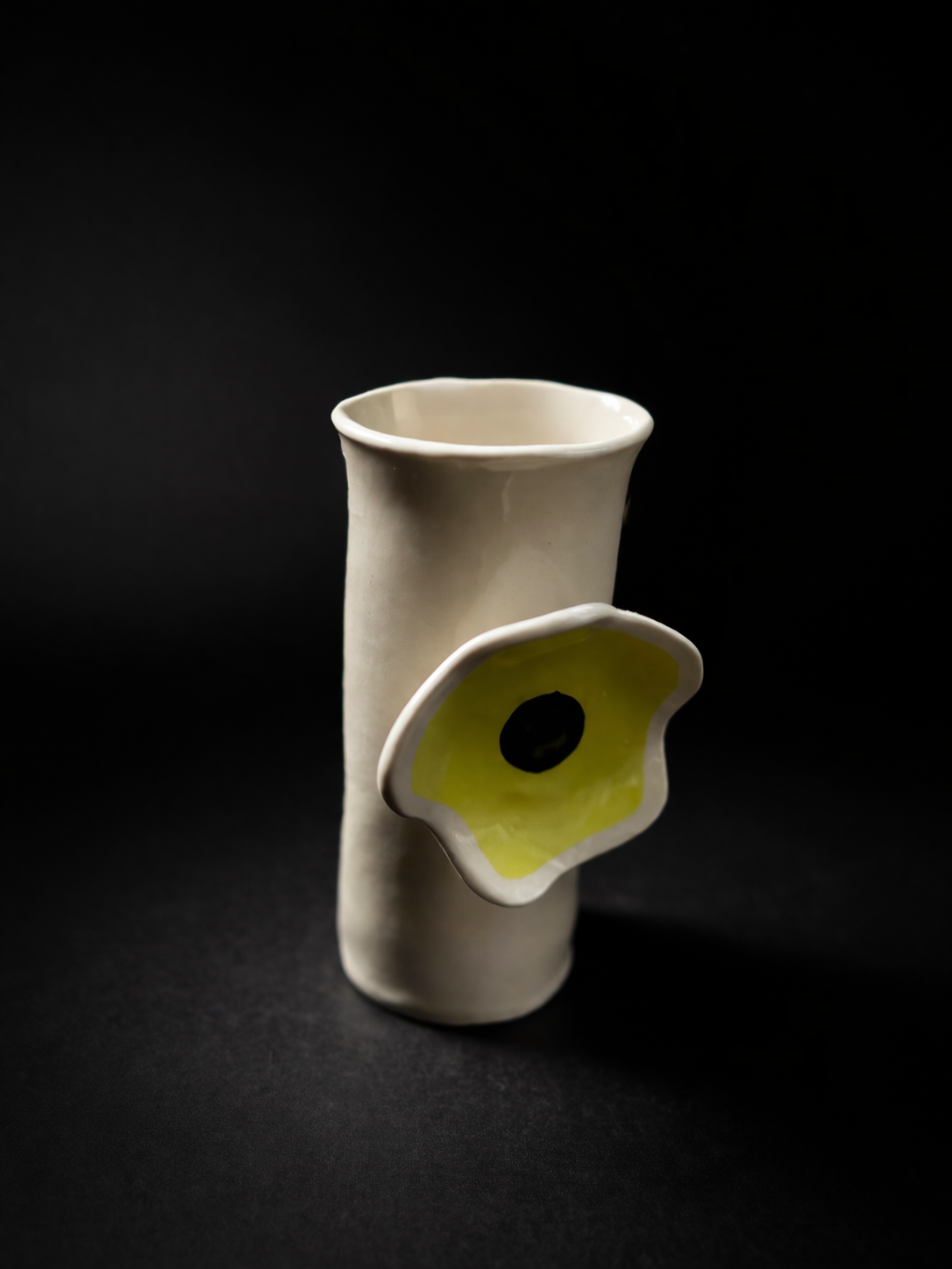 Minimalist ceramic vase with floral accent.png