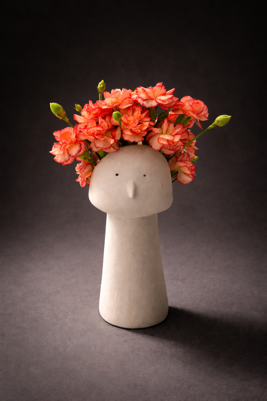 Ceramic head vase with carnations.png
