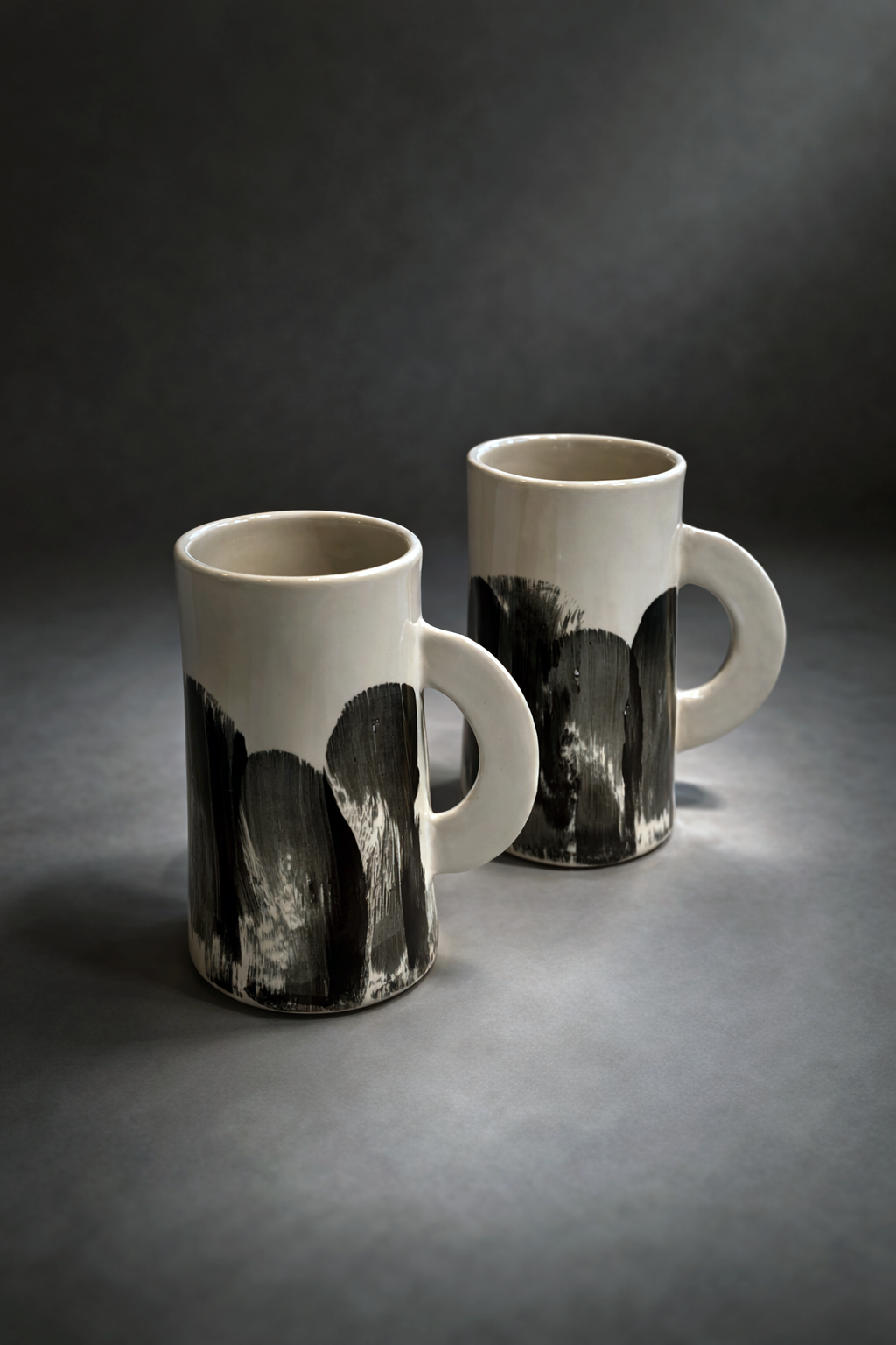 Minimalist ceramic mugs in soft light.png