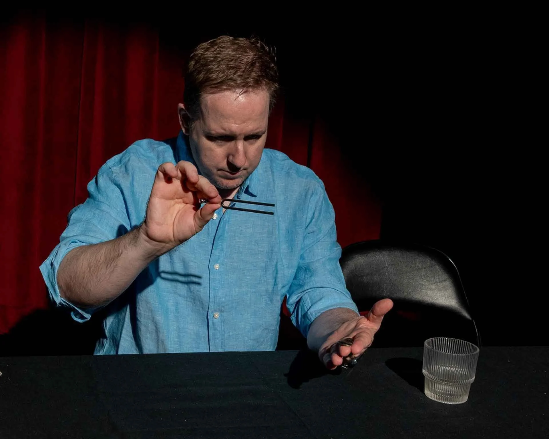 James Alan bending a coin in Mysteries and LIes at the Toronto Fringe Festival