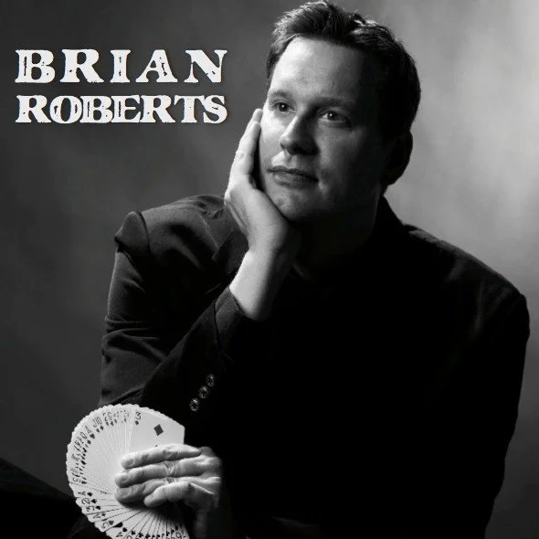 Brian Roberts black and white headshot holding a fan of cards