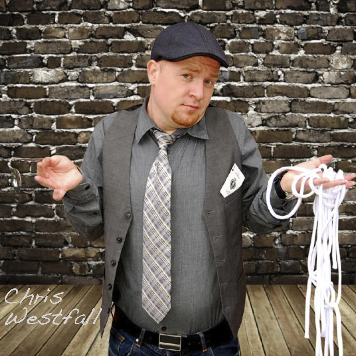 Chris Westfall promotional image holding too many magic props in front of brick wall