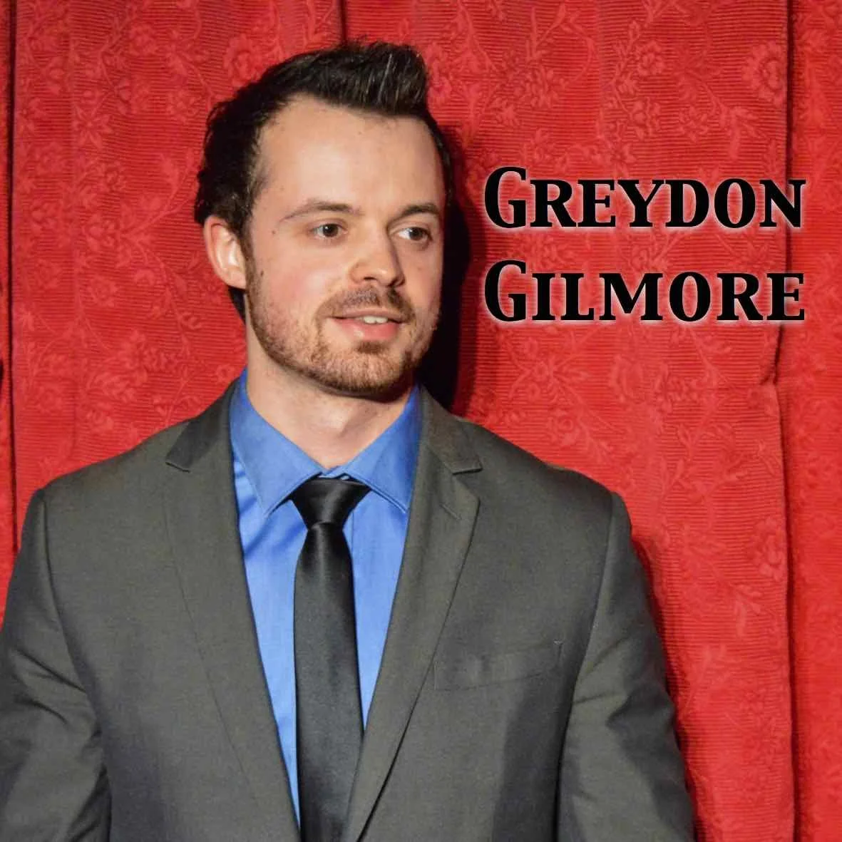 Greydon Gilmore Headshot in front of red curtain