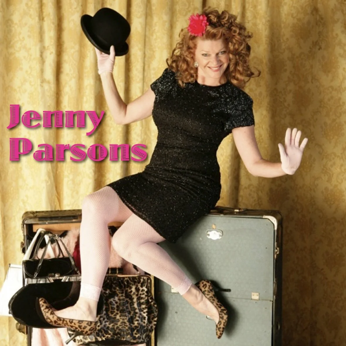 Jenny Parsons promotional photo sitting on luggage holding a top hat