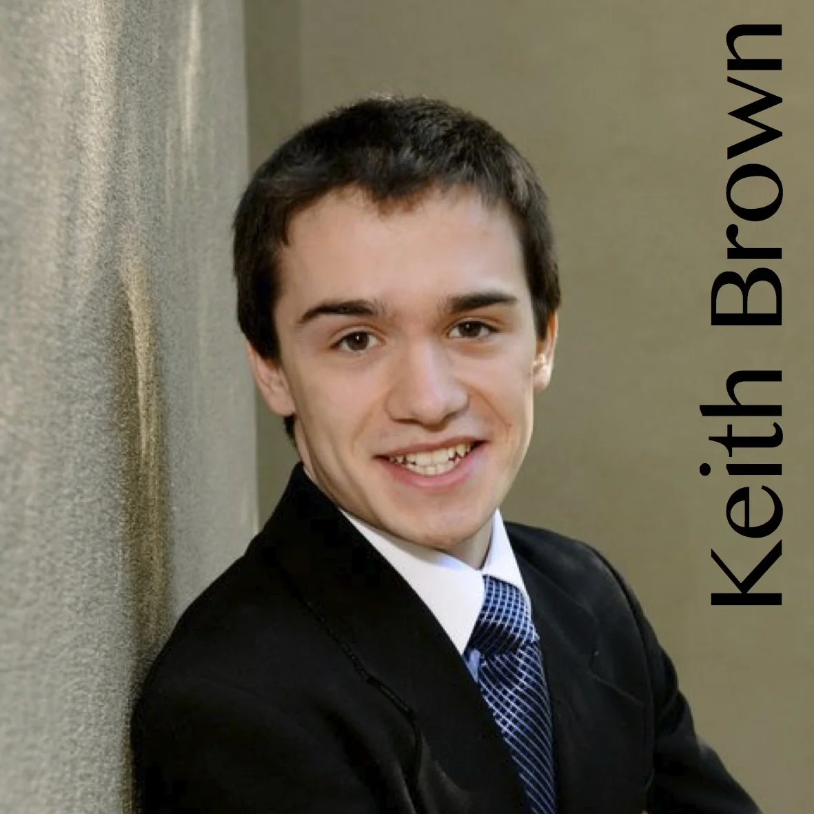 Keith Brown headshot leaning against a concrete wall